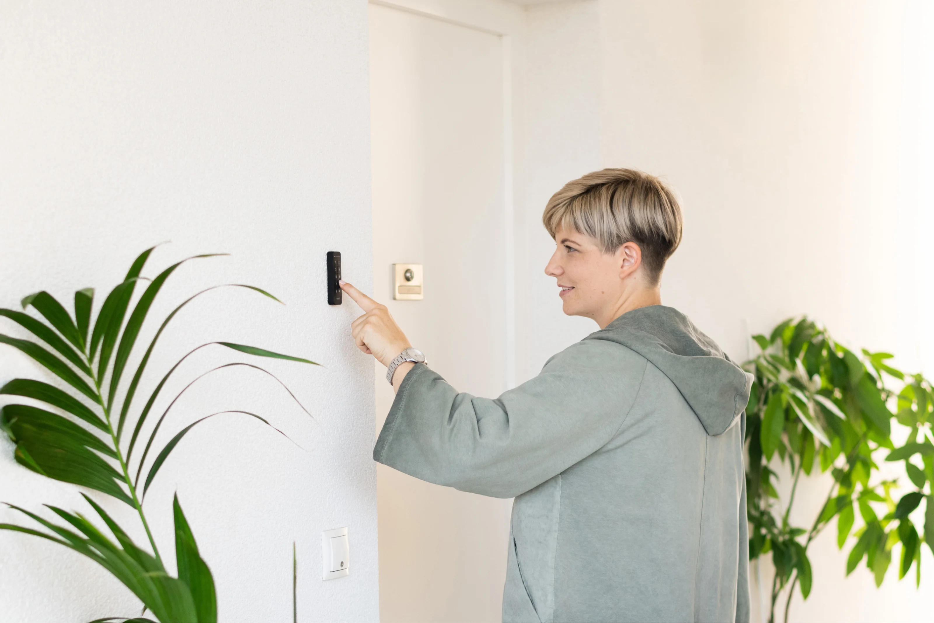 Person enters access code on the Nuki Keypad next to a door.