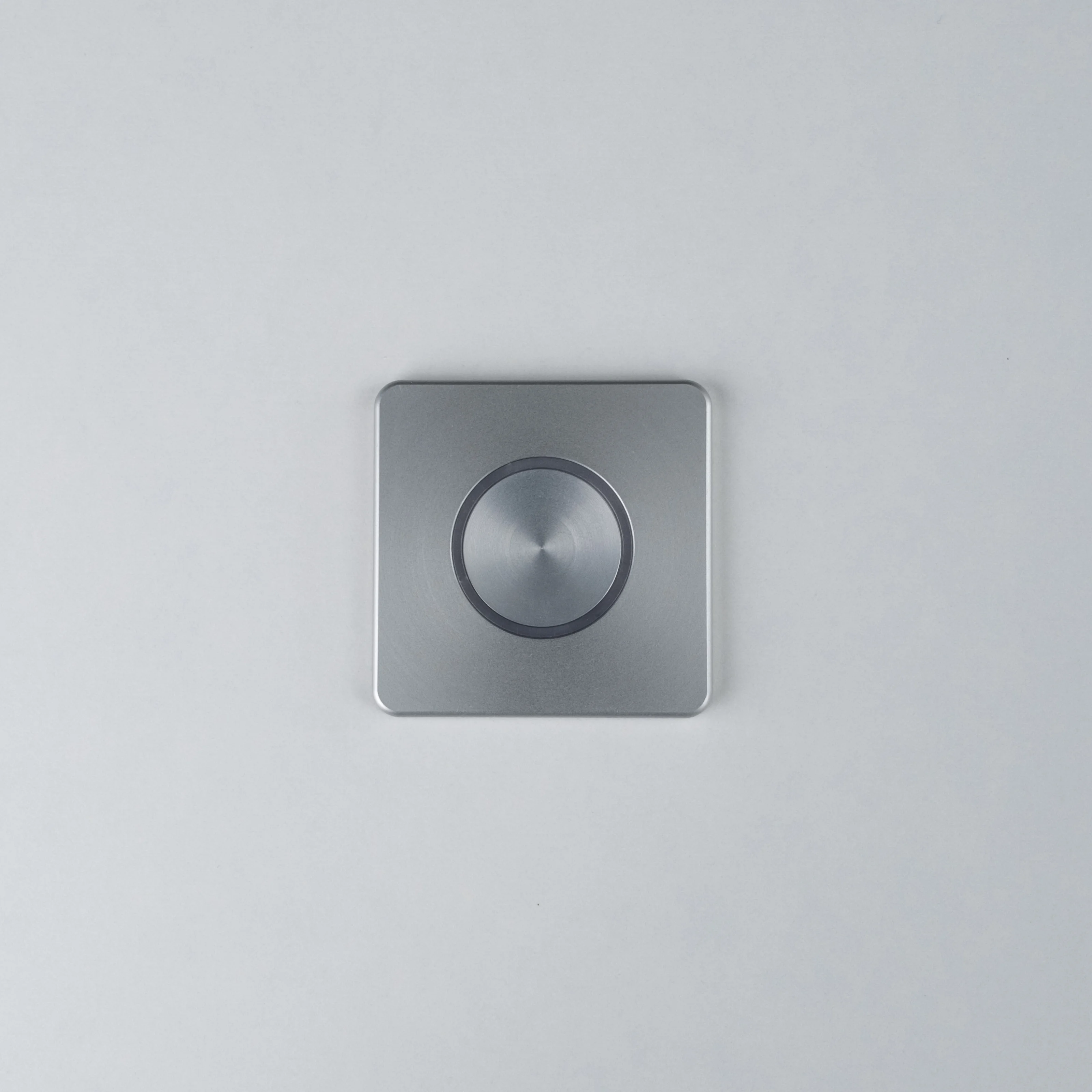 Silver Nuki Button, square, integrated in a white door – turns a mechanical lock into a smart door.