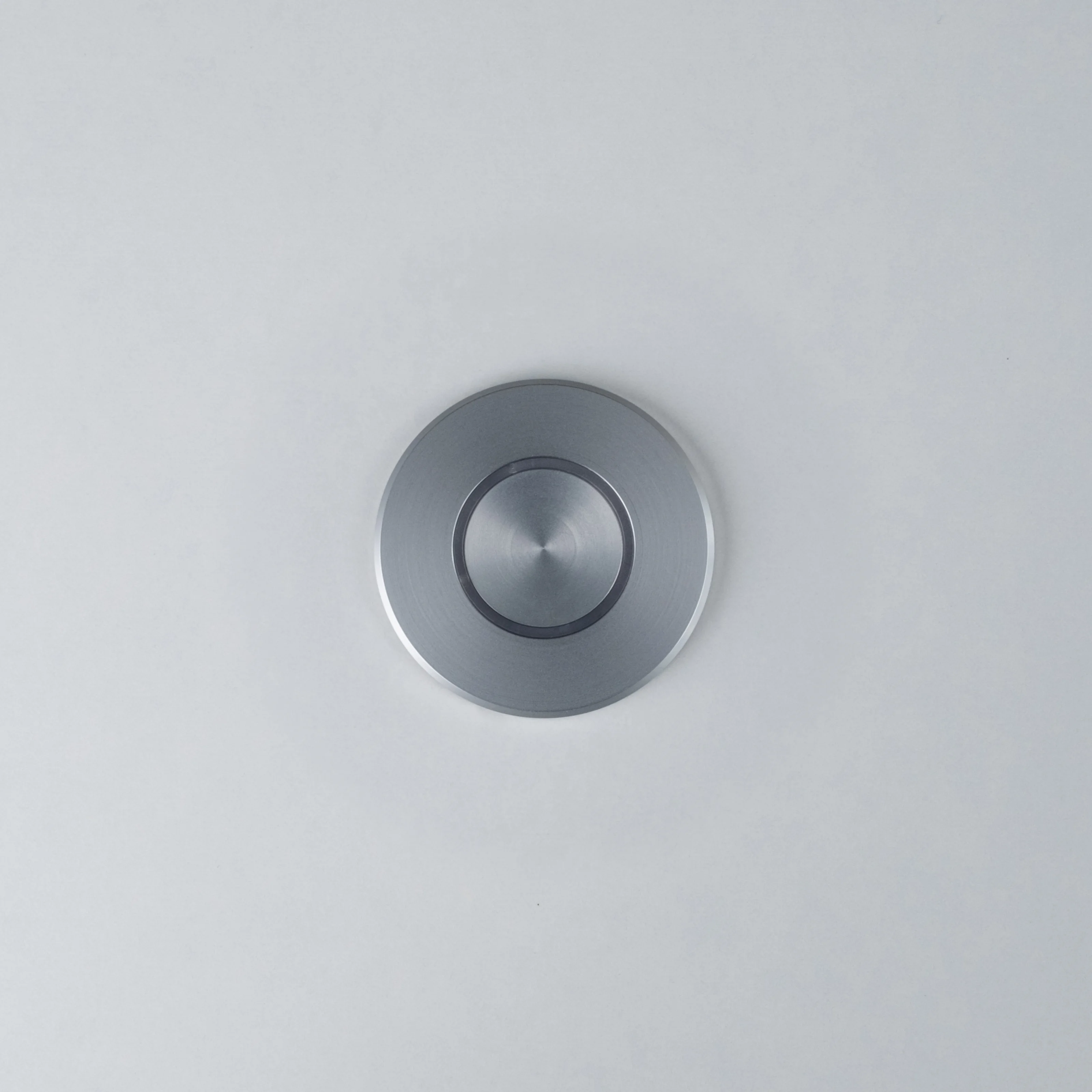 Silver Nuki Button, round, integrated in a white door – turns a mechanical lock into a smart door.