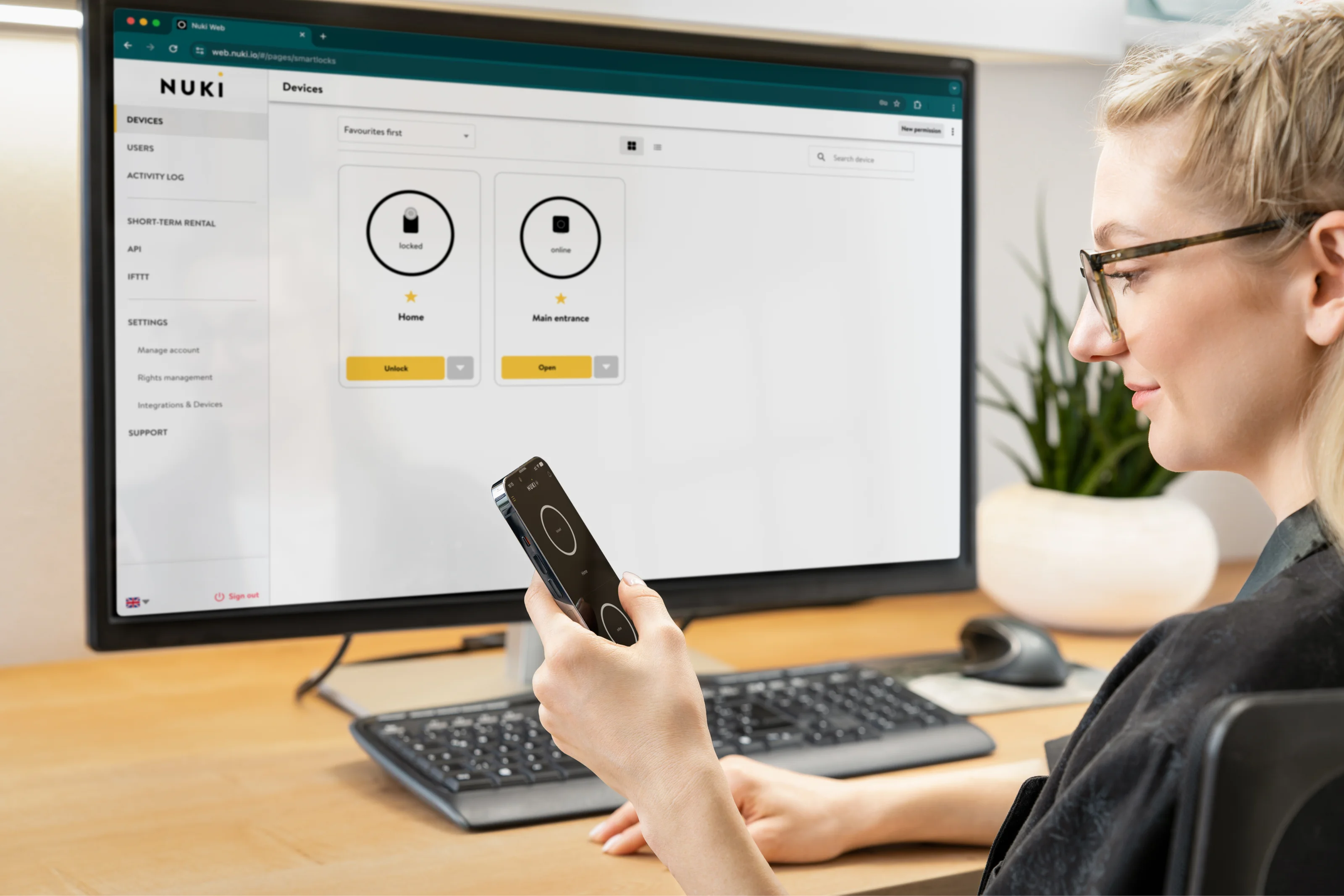 Woman uses smartphone and Nuki Web interface to manage smart locks.