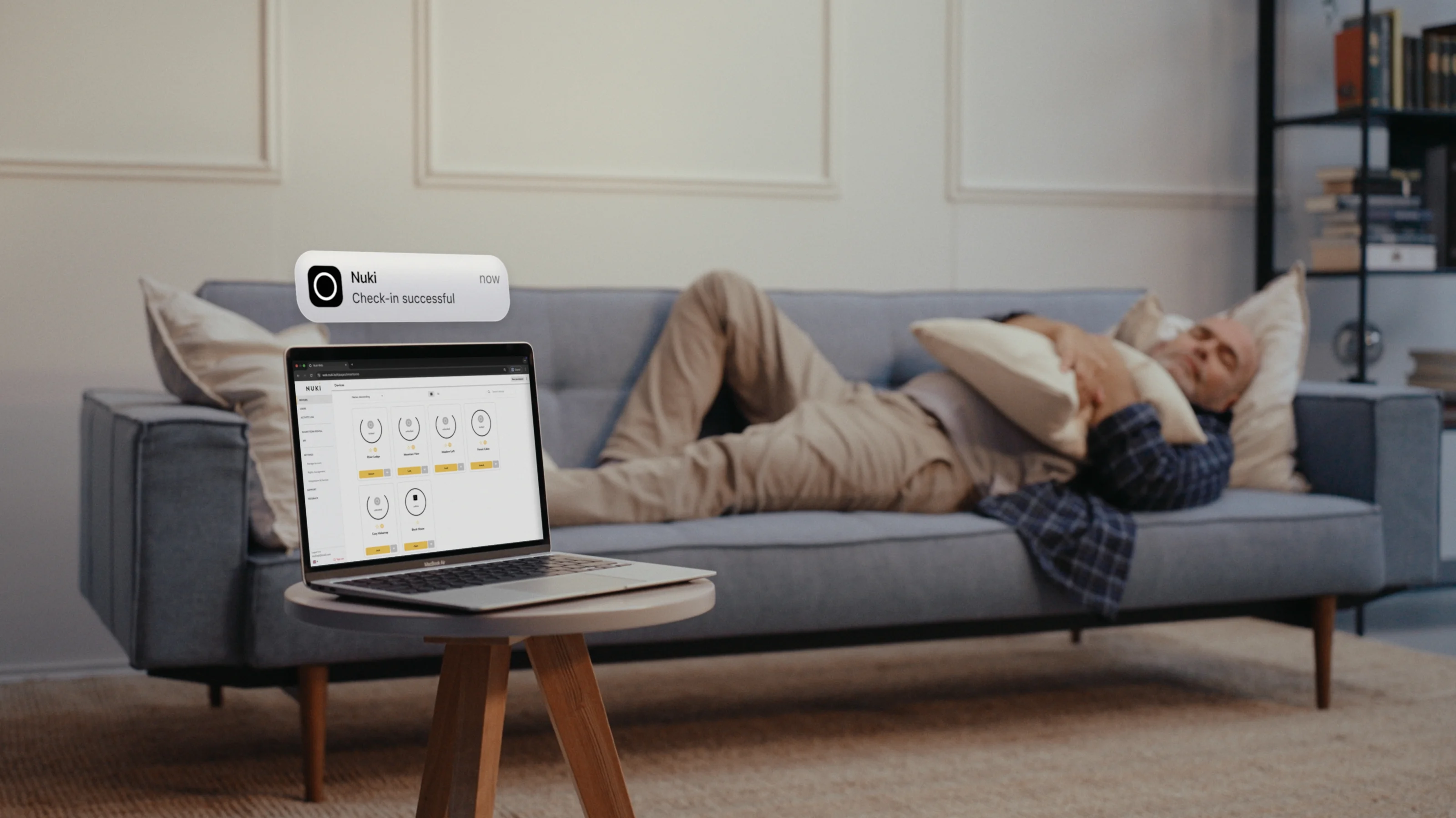 Man relaxing while managing door access via the Nuki app on his laptop – smart control from anywhere.