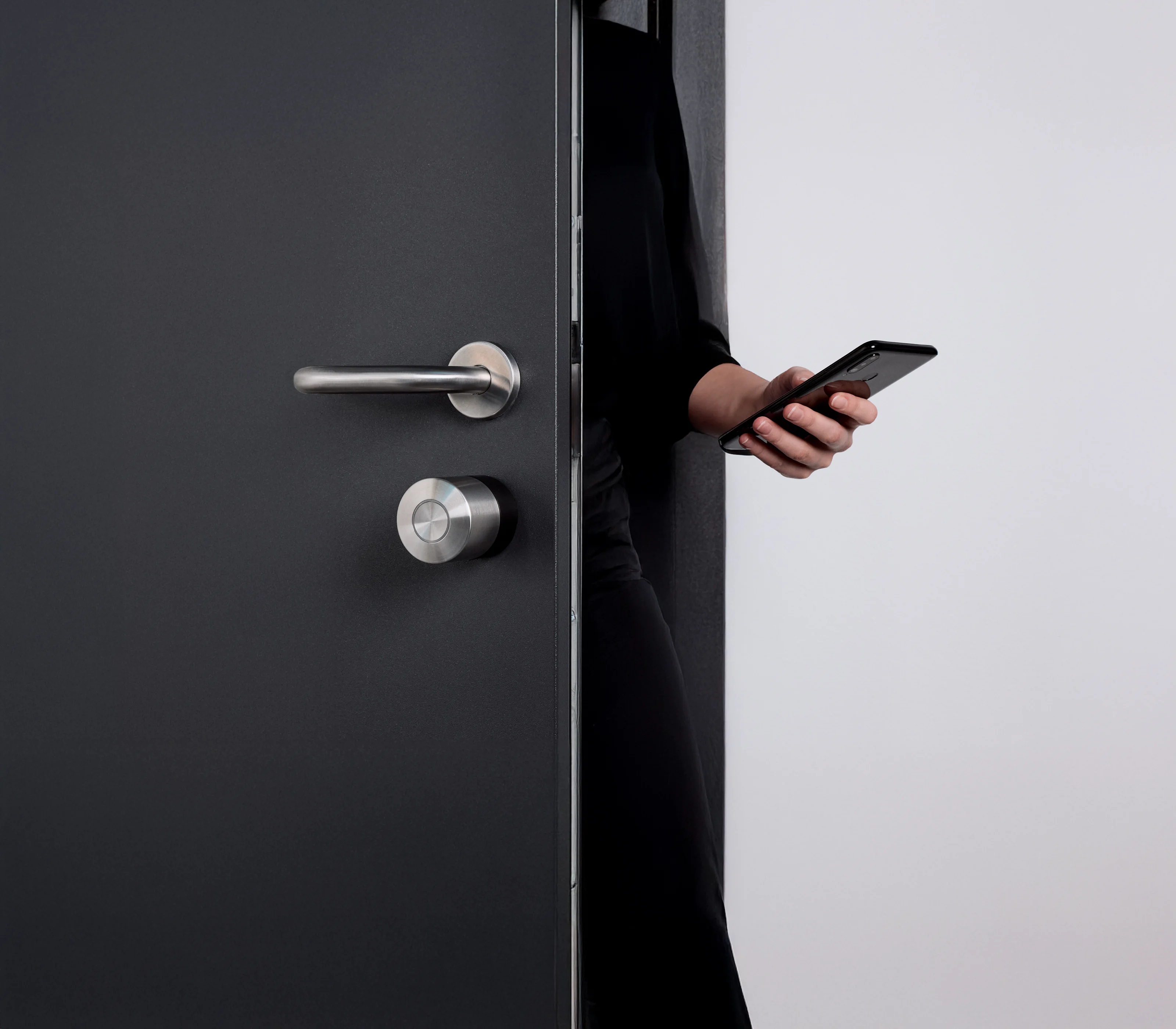 Person unlocking the door with their smartphone using the Nuki Smart Lock Pro – secure and touch-free access.