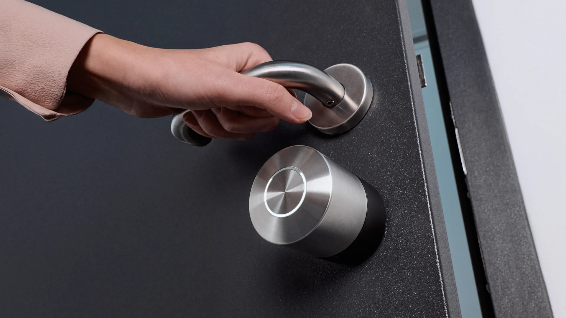 Hand reaching for the door handle next to the Nuki Smart Lock Pro – smart access made simple.