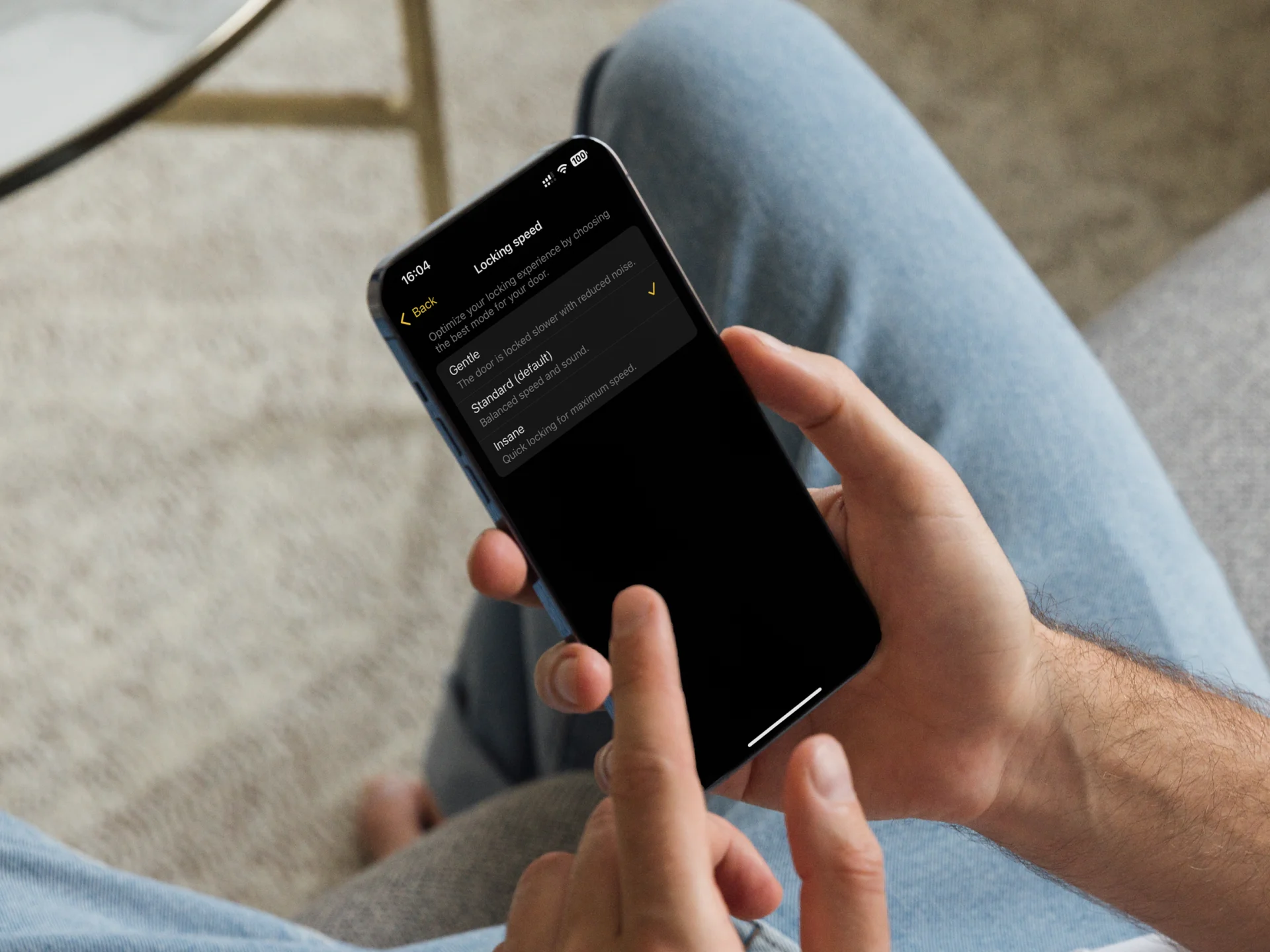 Person using the Nuki app to manage smart lock settings – secure control from the sofa.