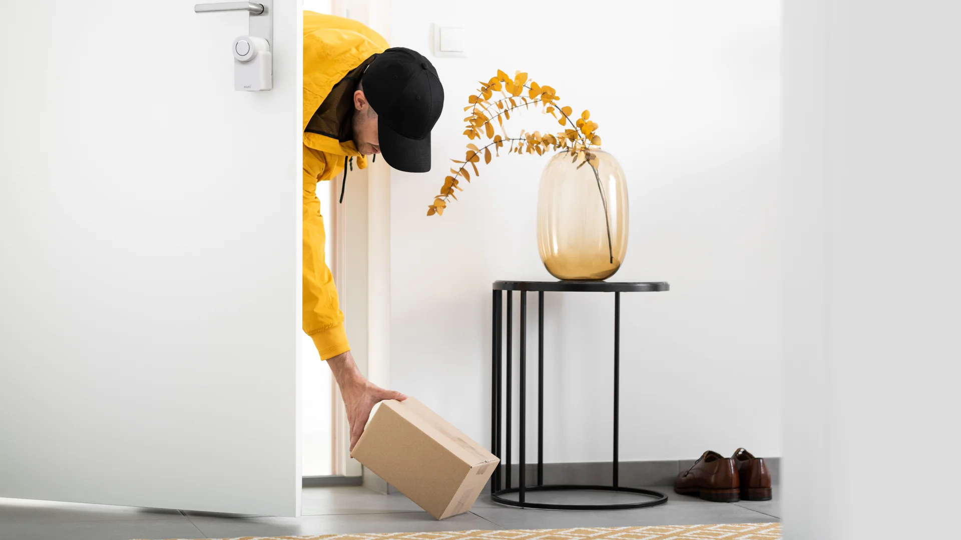 Delivery person places package inside open door with Nuki Smart Lock.