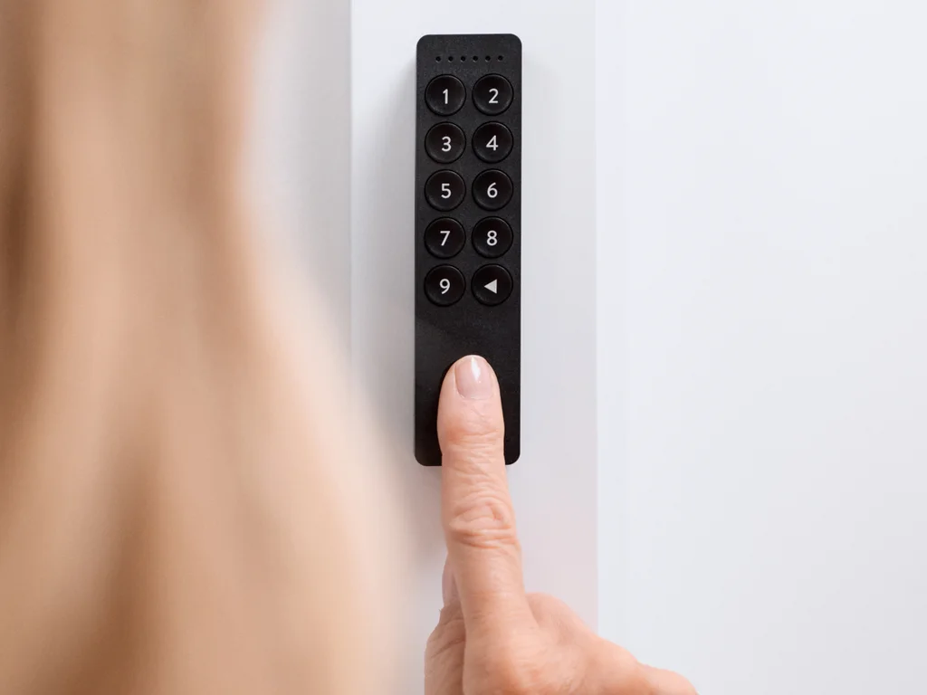 A woman uses the Nuki Keypad 2 by putting her finger on the Fingerprint sensor.