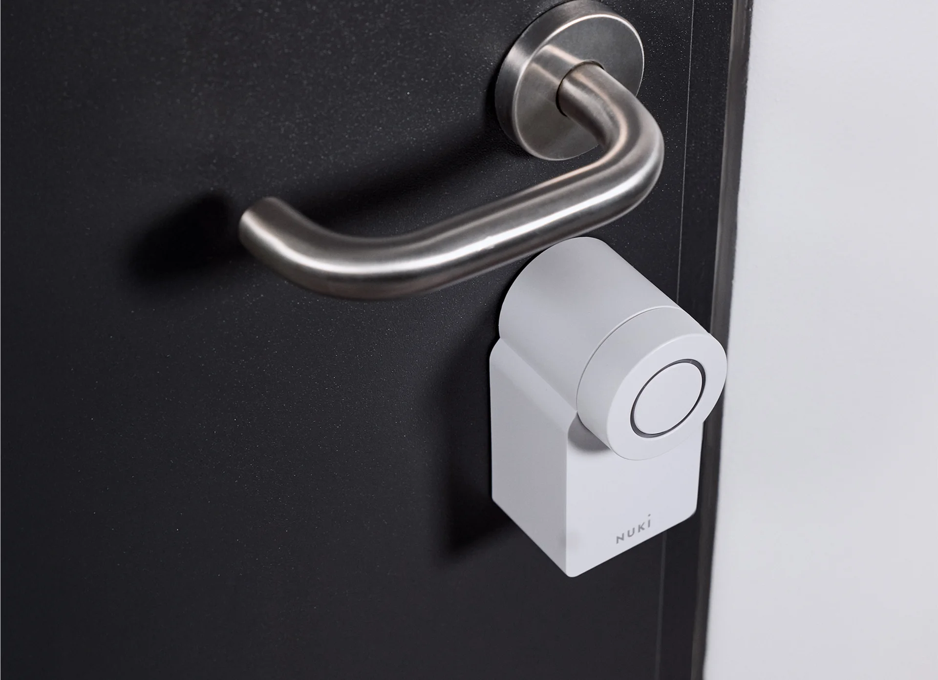 Smart Lock Go mounted on the inside of a door, below a silver door handle.