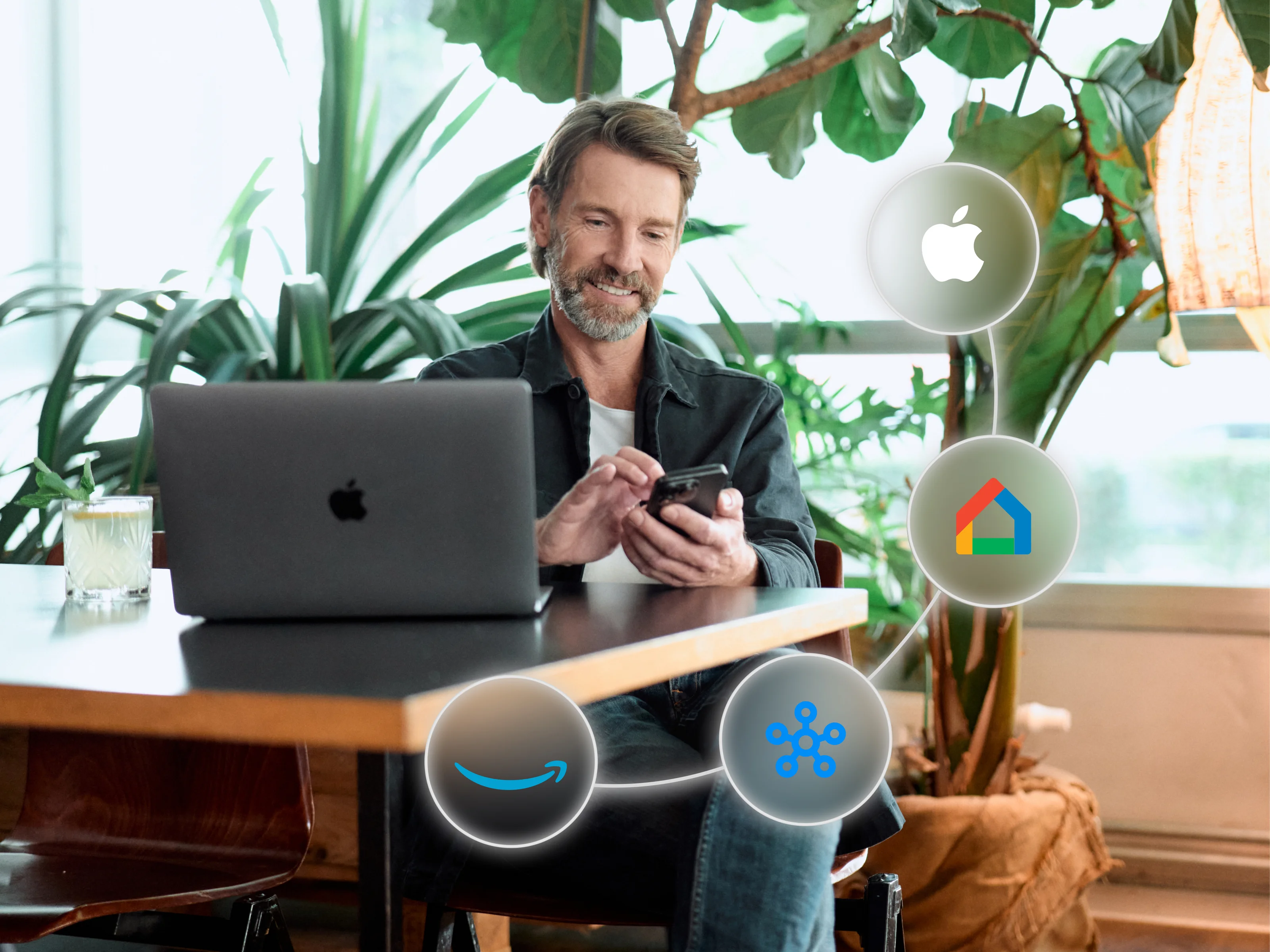 Man with smartphone and MacBook, surrounded by icons for Apple, Google Home, Alexa, and SmartThings.