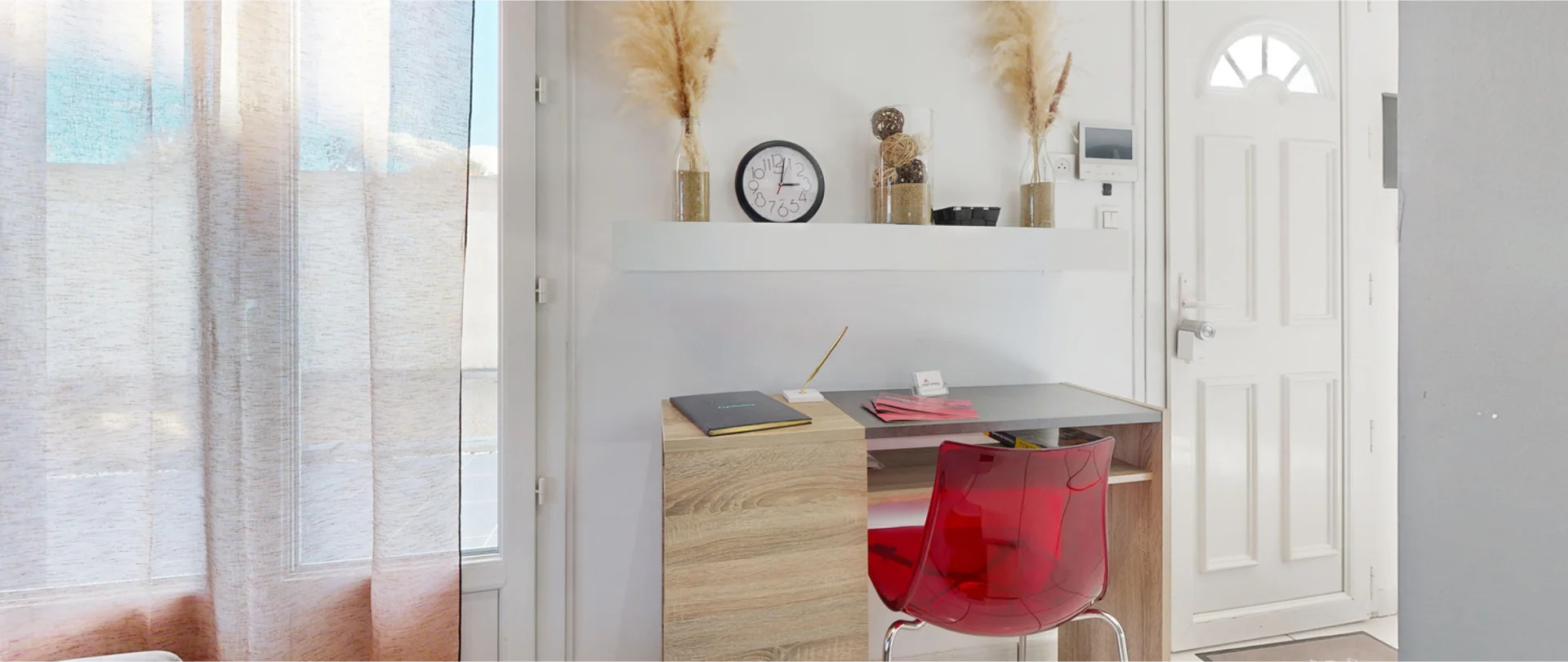 Intérieur d’un appartement avec grande fenêtre, bureau et design moderne et neutre.