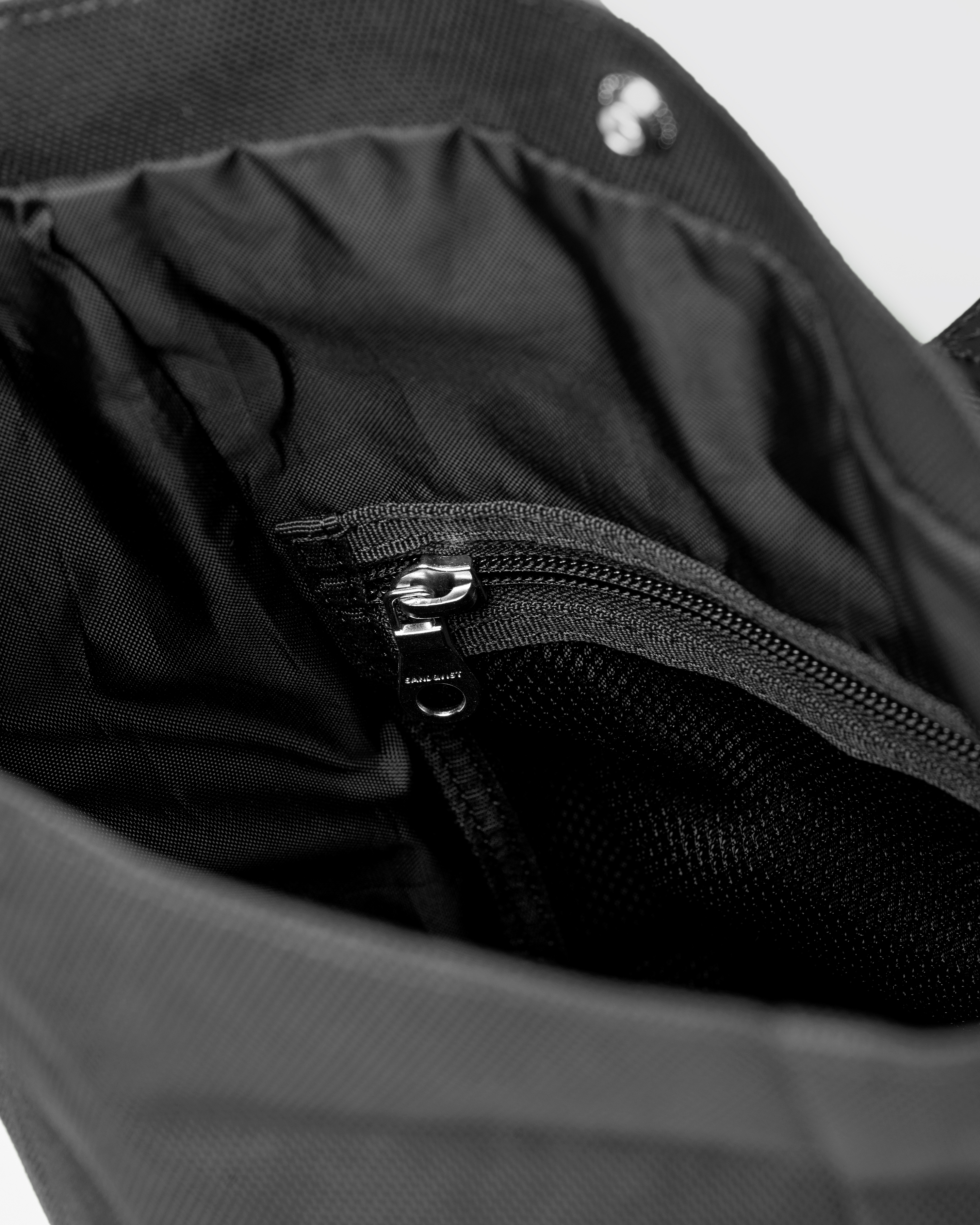 Inside view of main compartment with press button and zipper mesh pocket for Sandqvist ICON Sacoche in Black. 
