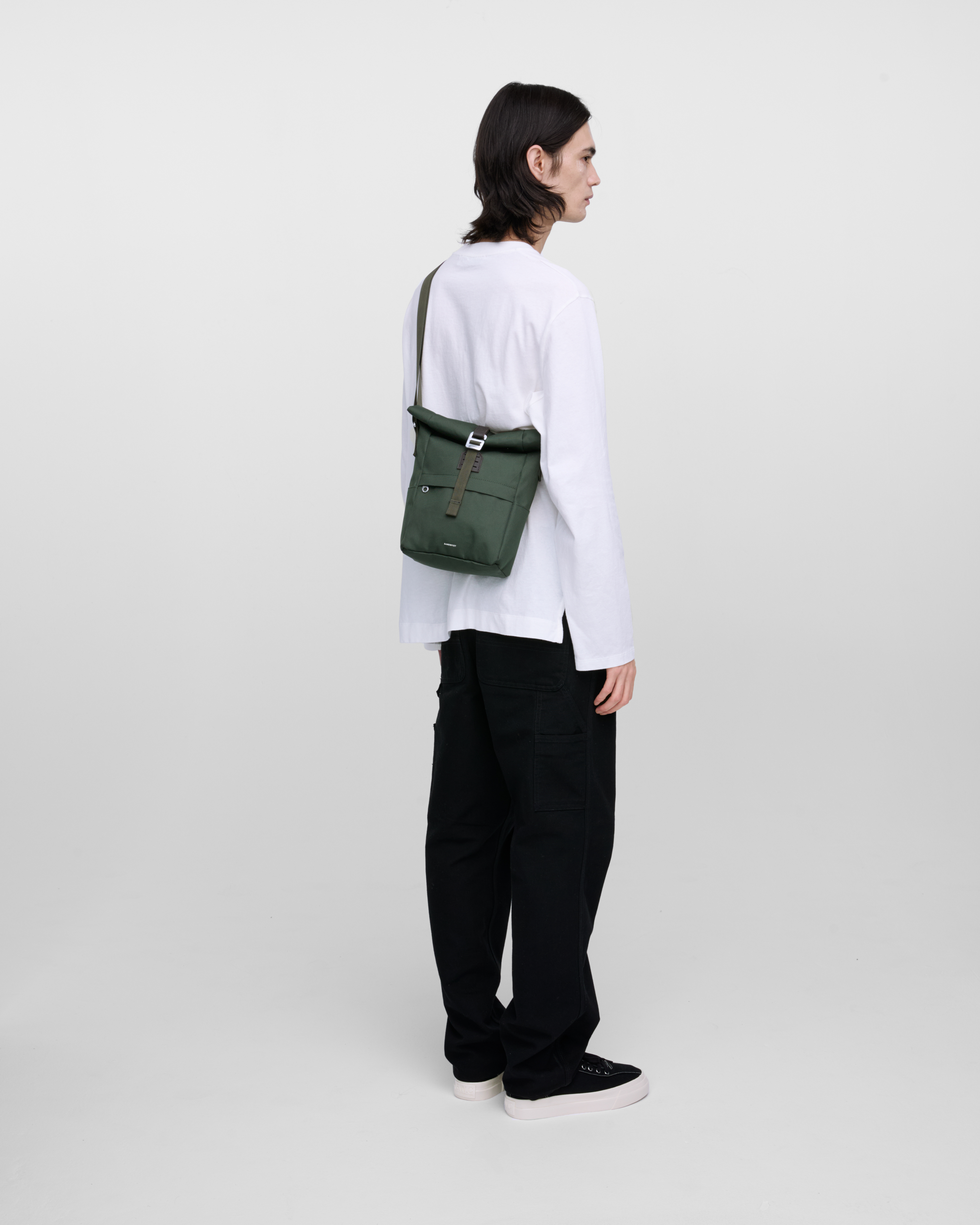 Crossbody bag. Sandqvist ICON Sacoche in Dark Green on a male model. Back view showing fit and size.