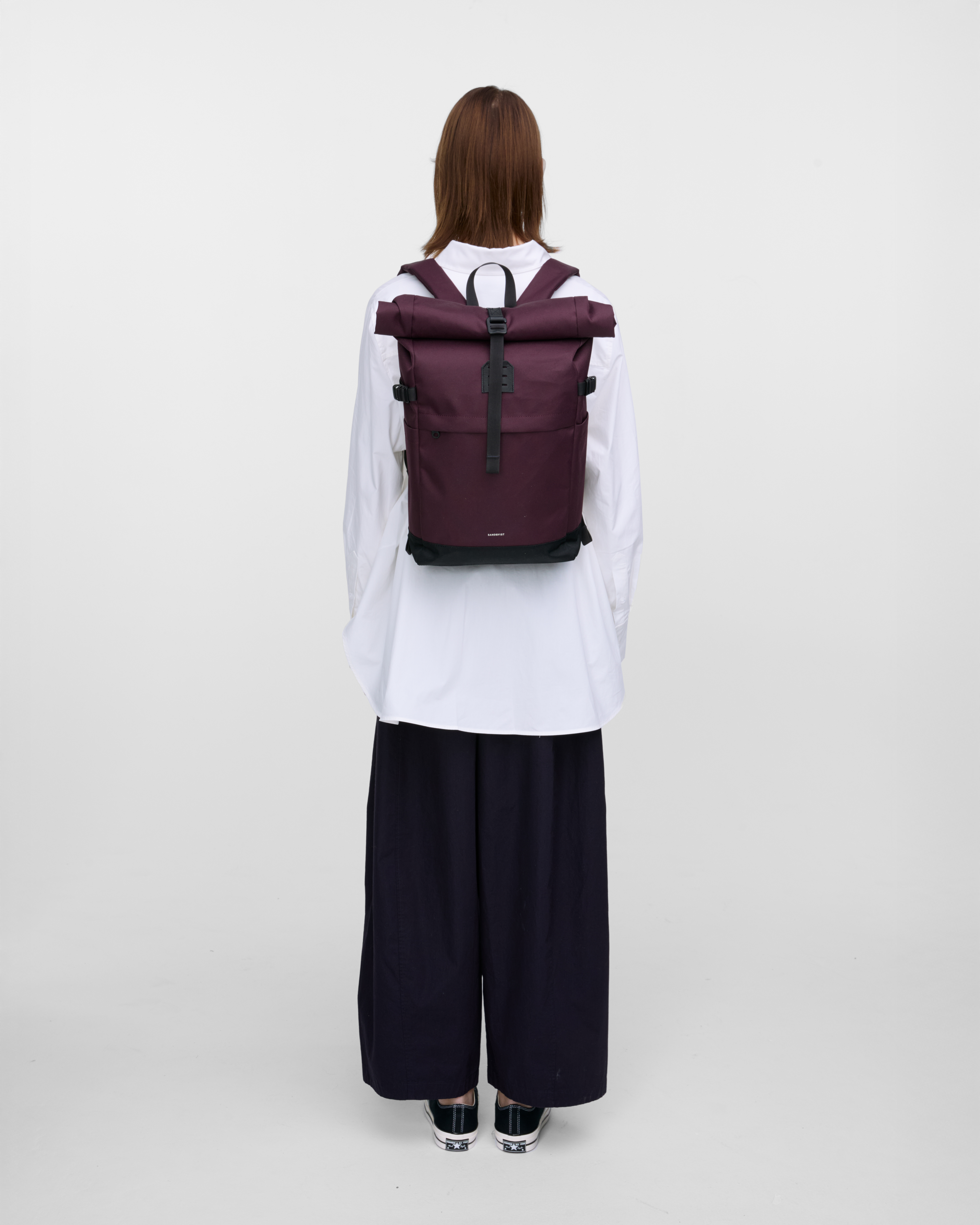 Mannequin féminin vu de dos portant le sac à dos ICON Rolltop backpack M en violet, montrant la taille et la coupe.