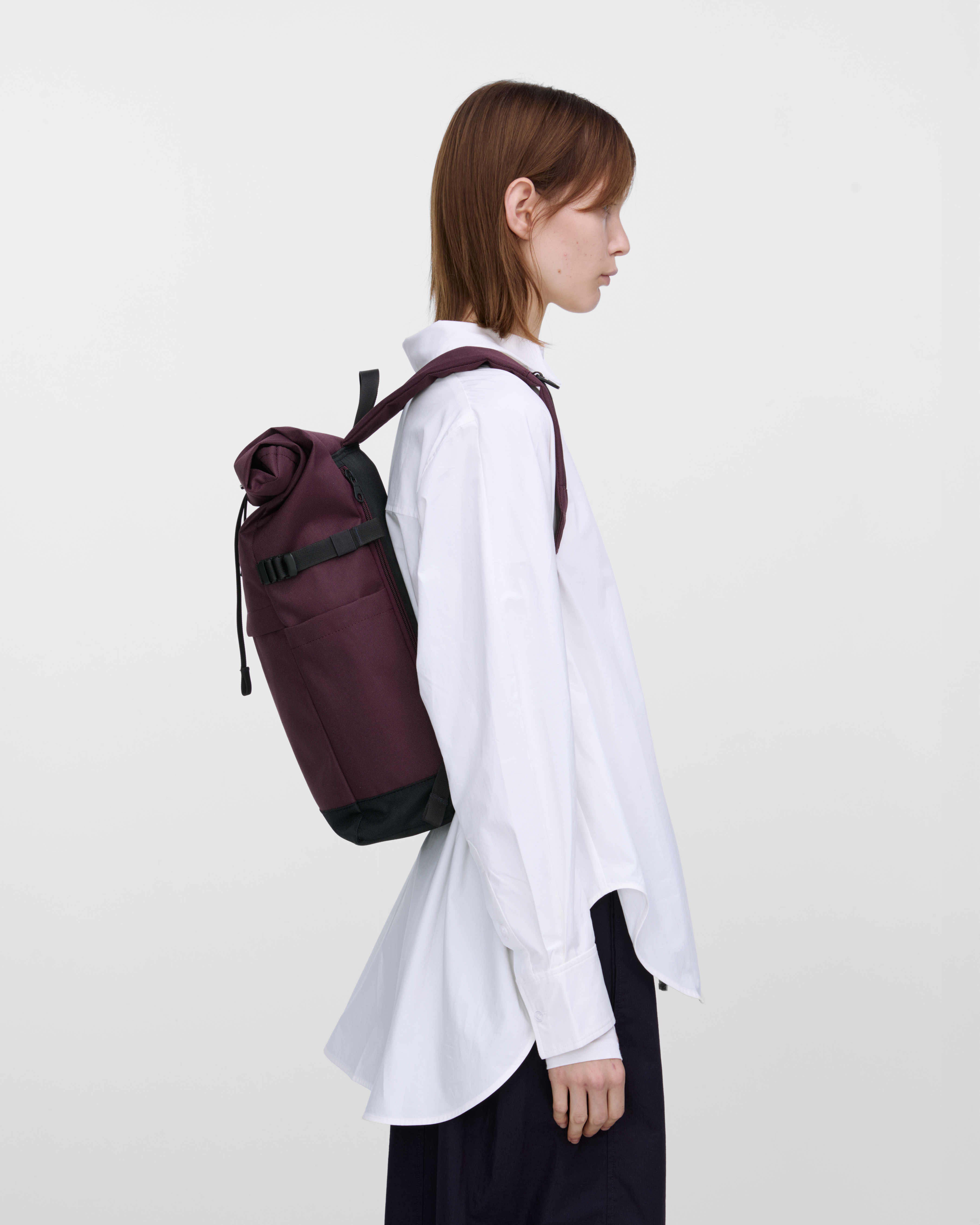 Mannequin féminin portant un sac à dos Sandqvist ICON Rolltop Backpack M violet, vue de profil montrant la coupe et la taille.