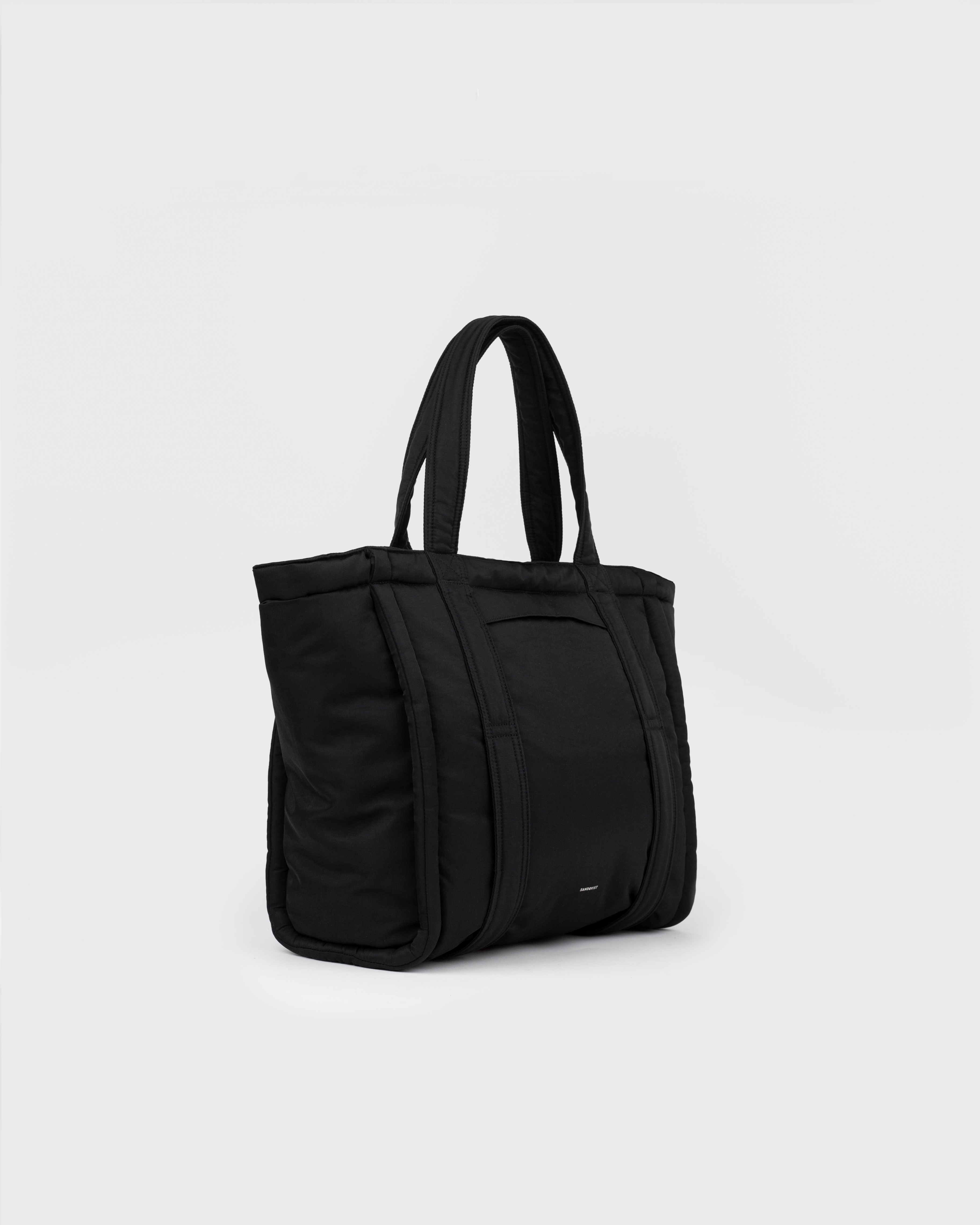 Sandqvist Curve Tote Bag, black. Side view with handles.
