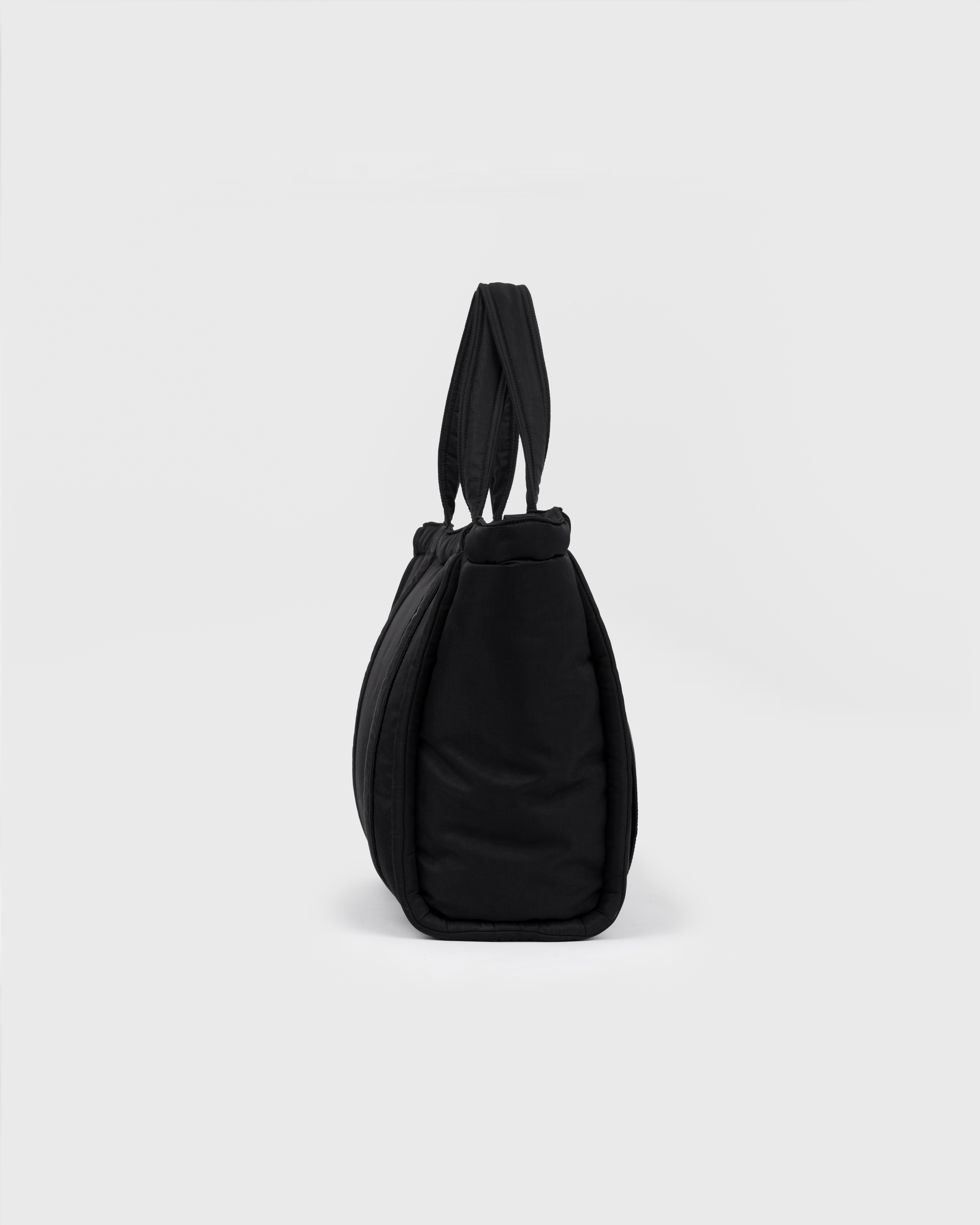Sandqvist Curve Tote Bag, black. Side view with handles.