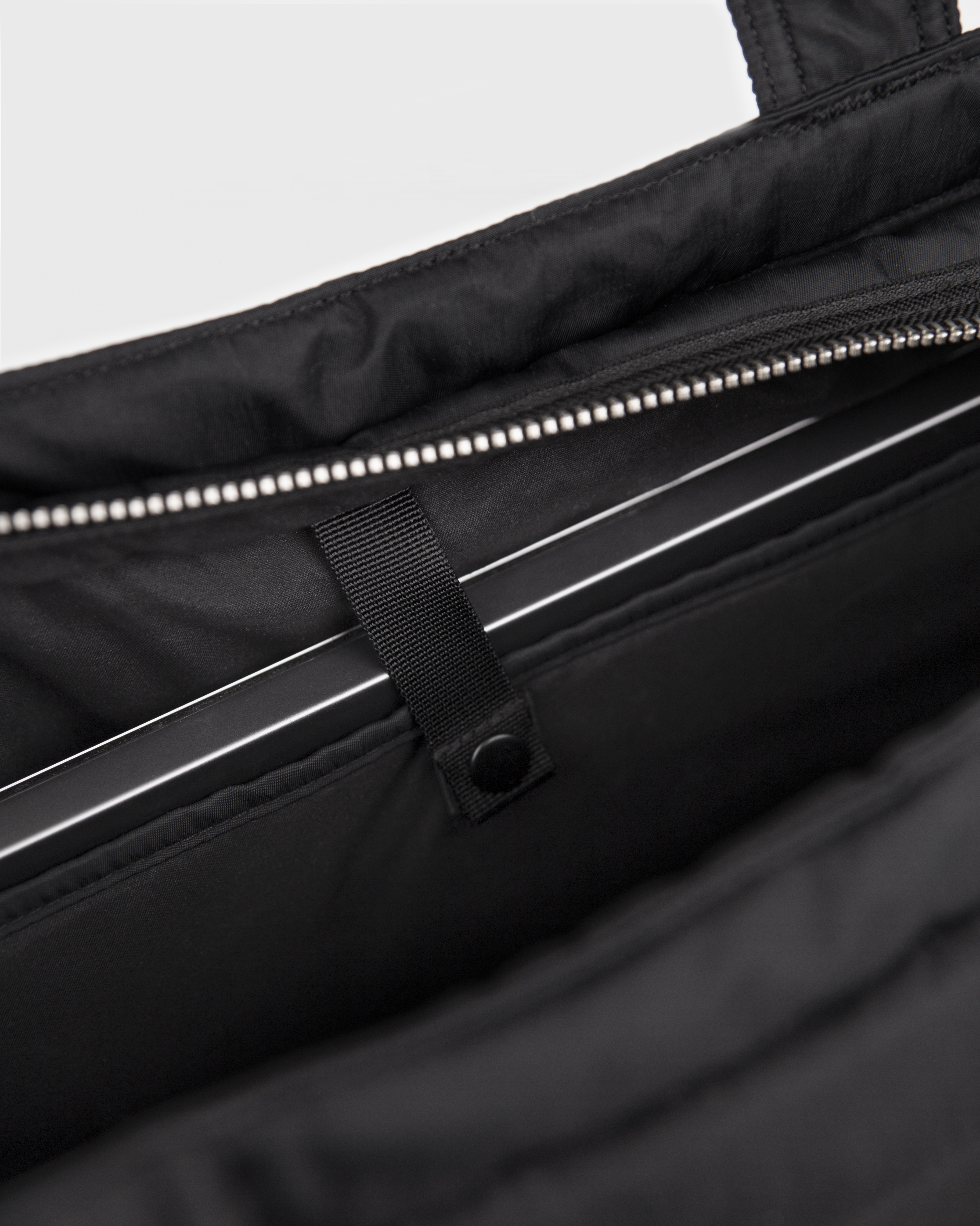Sandqvist Curve Tote Bag, black. Inside view, laptop compartment with snap button.