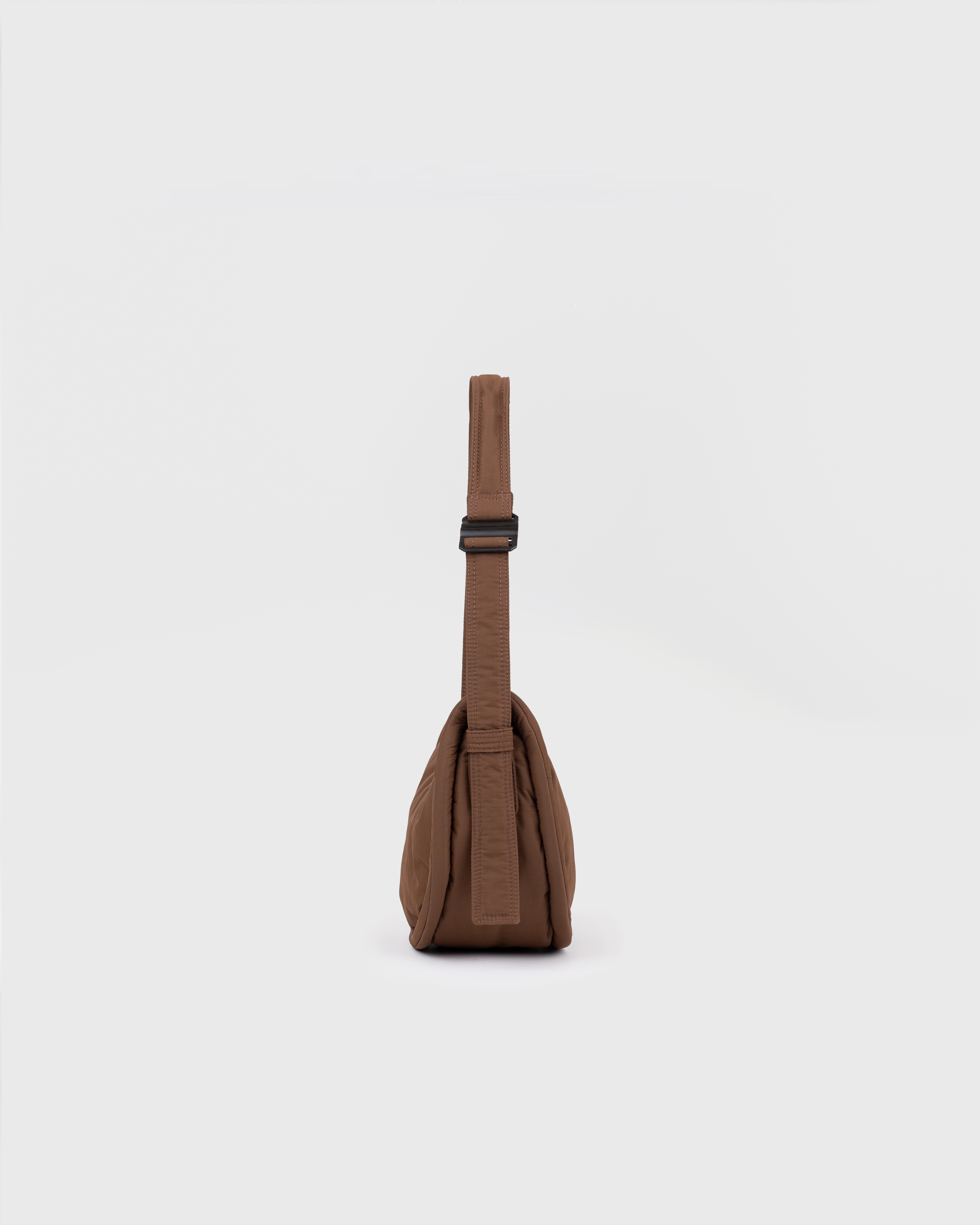 Handbag. Sandqvist Curve Half Moon Bag Mini, brown. Side view, shoulder strap with adjuster.