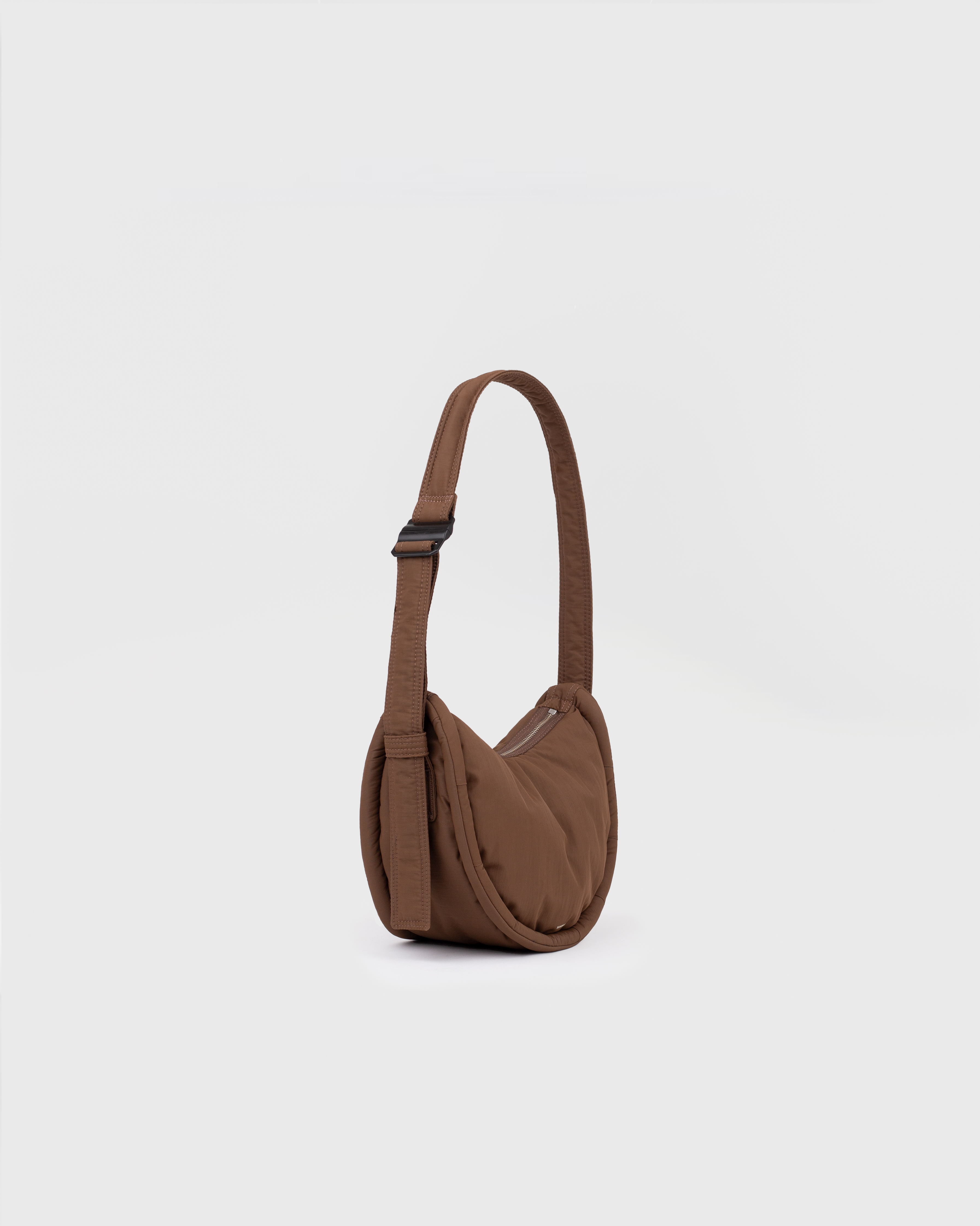 Handbag. Sandqvist Curve Half Moon Bag Mini, brown. Side view, shoulder strap with adjuster.