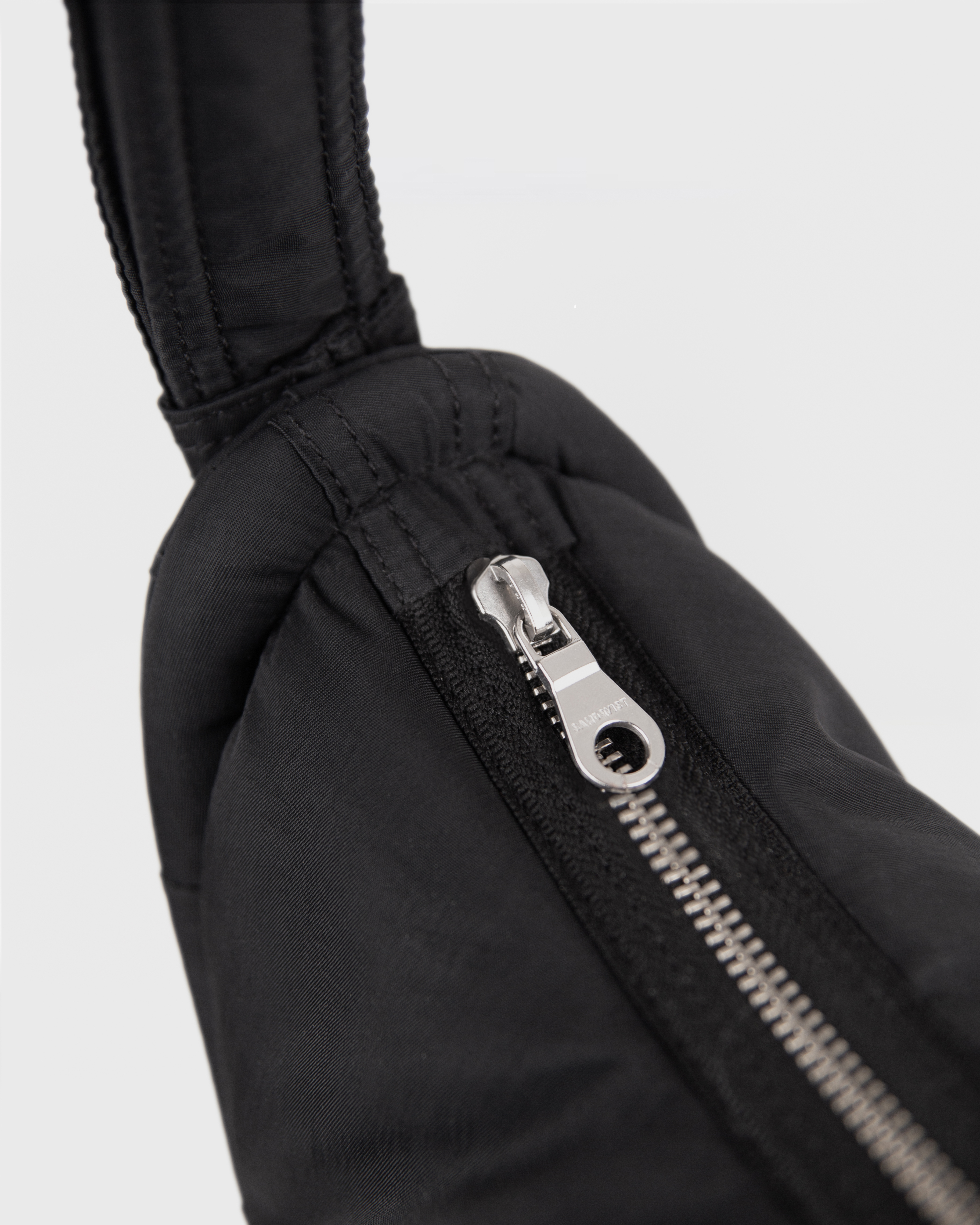 Close-up of the zipper of Sandqvist Curve Half Moon Bag mini, black.