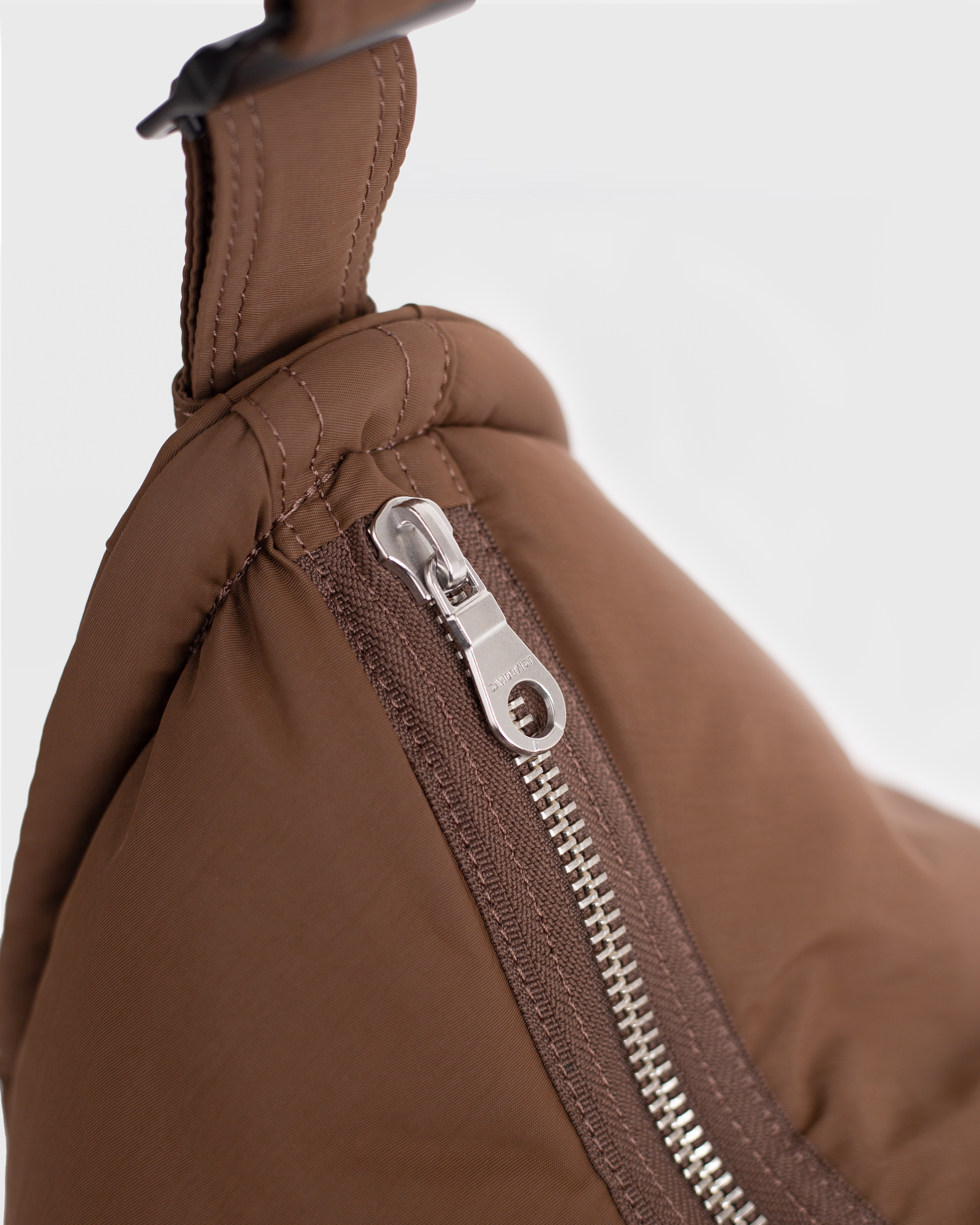 Nahaufnahme des Reißverschlusses der Sandqvist Curve Half Moon Tasche, braun.