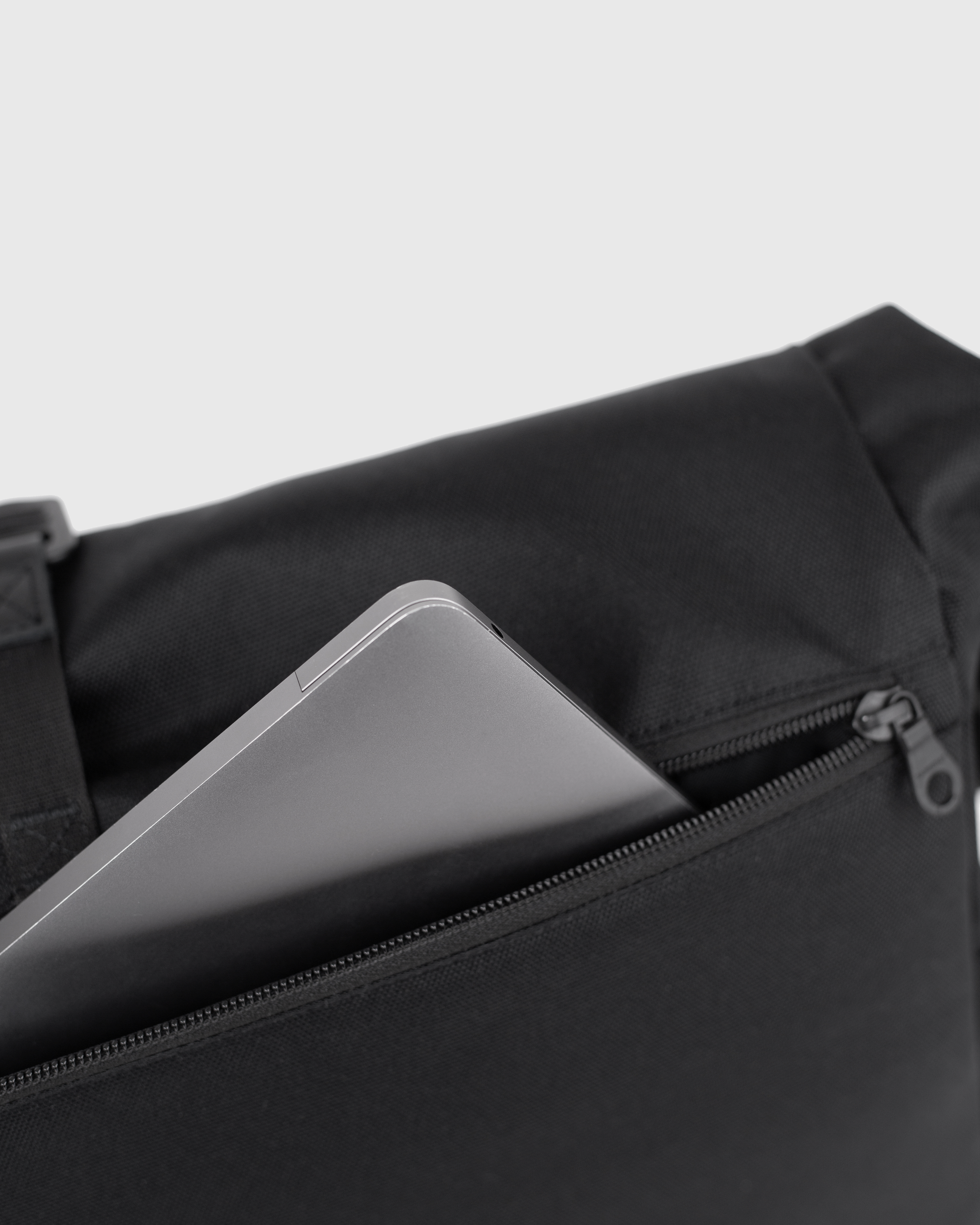 Sandqvist Icon Messenger Bag, black. Close-up of the outer laptop compartment with a zipper.