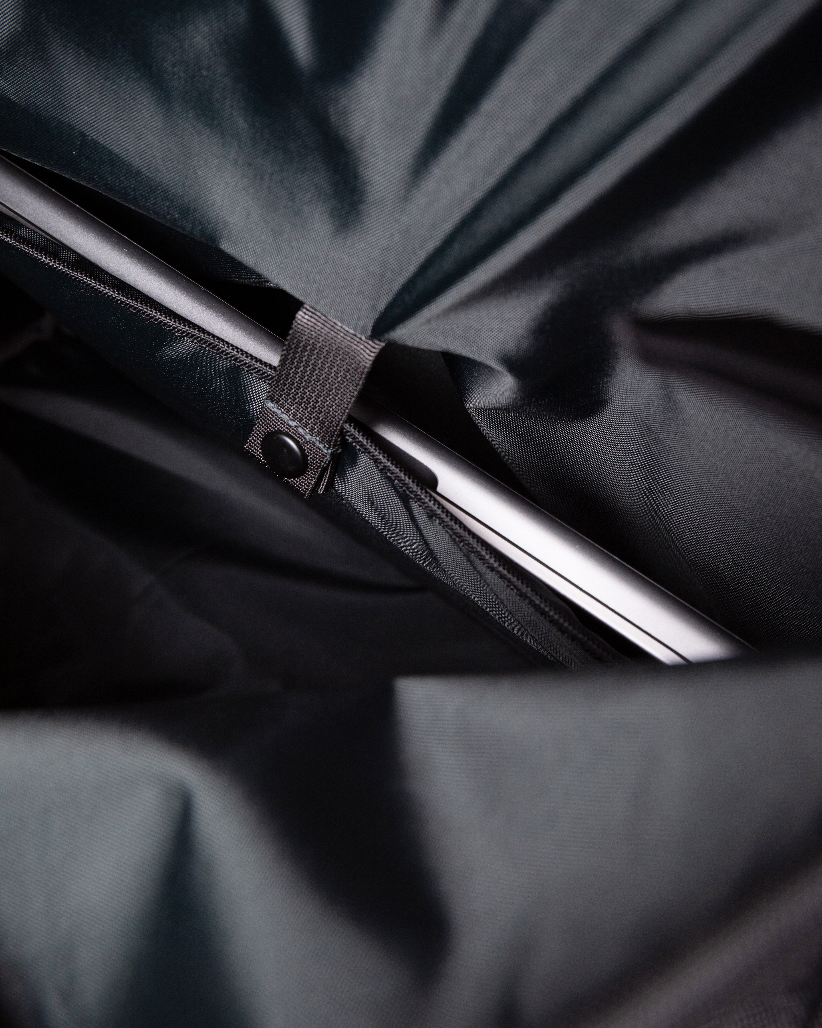 Sandqvist Icon Messenger Bag, black. Inside view of laptop compartment with snap button.