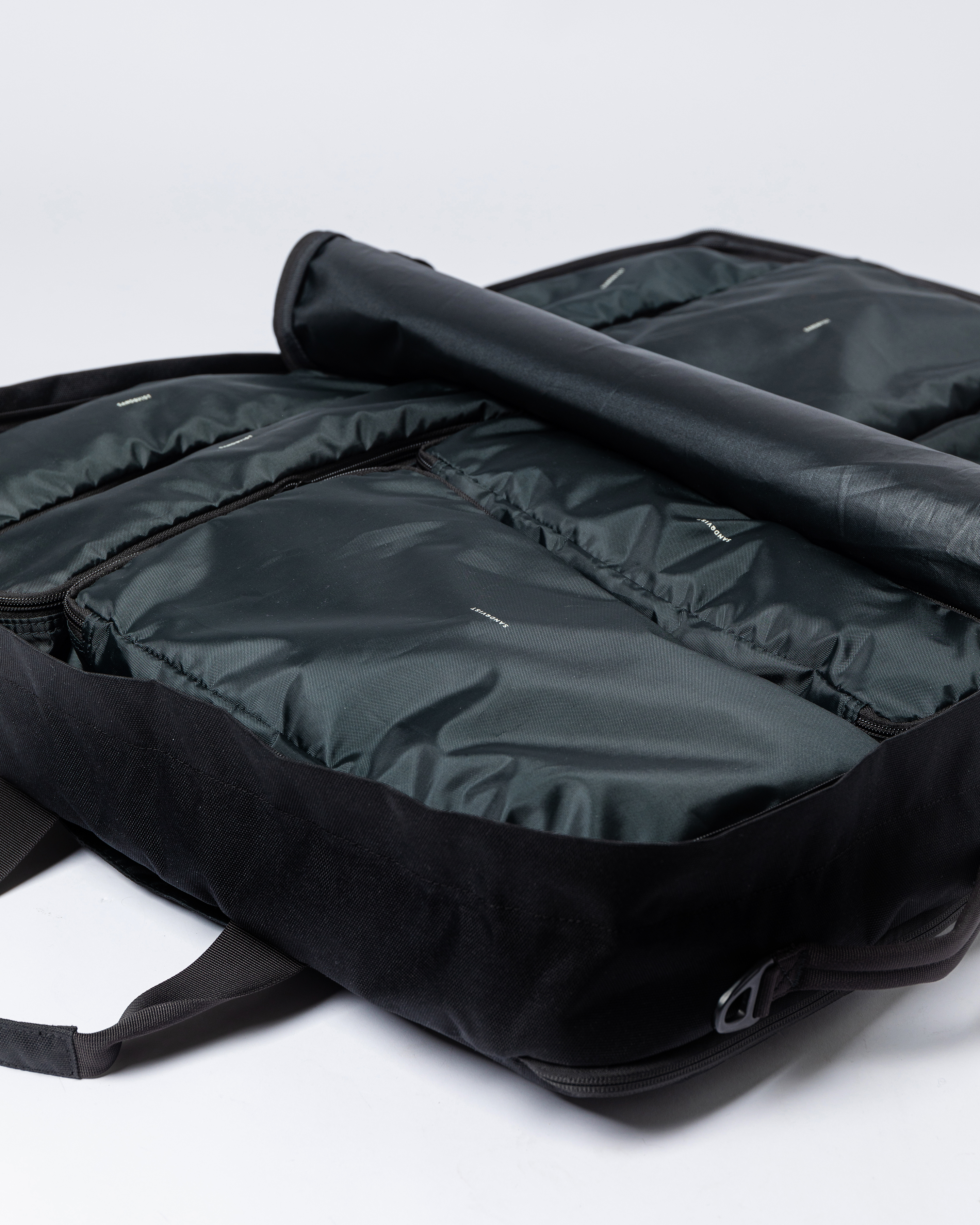 Sandqvist GO 3-way Bag M fully opened with four packing cubes on the left side and three packing cubes on the right side.