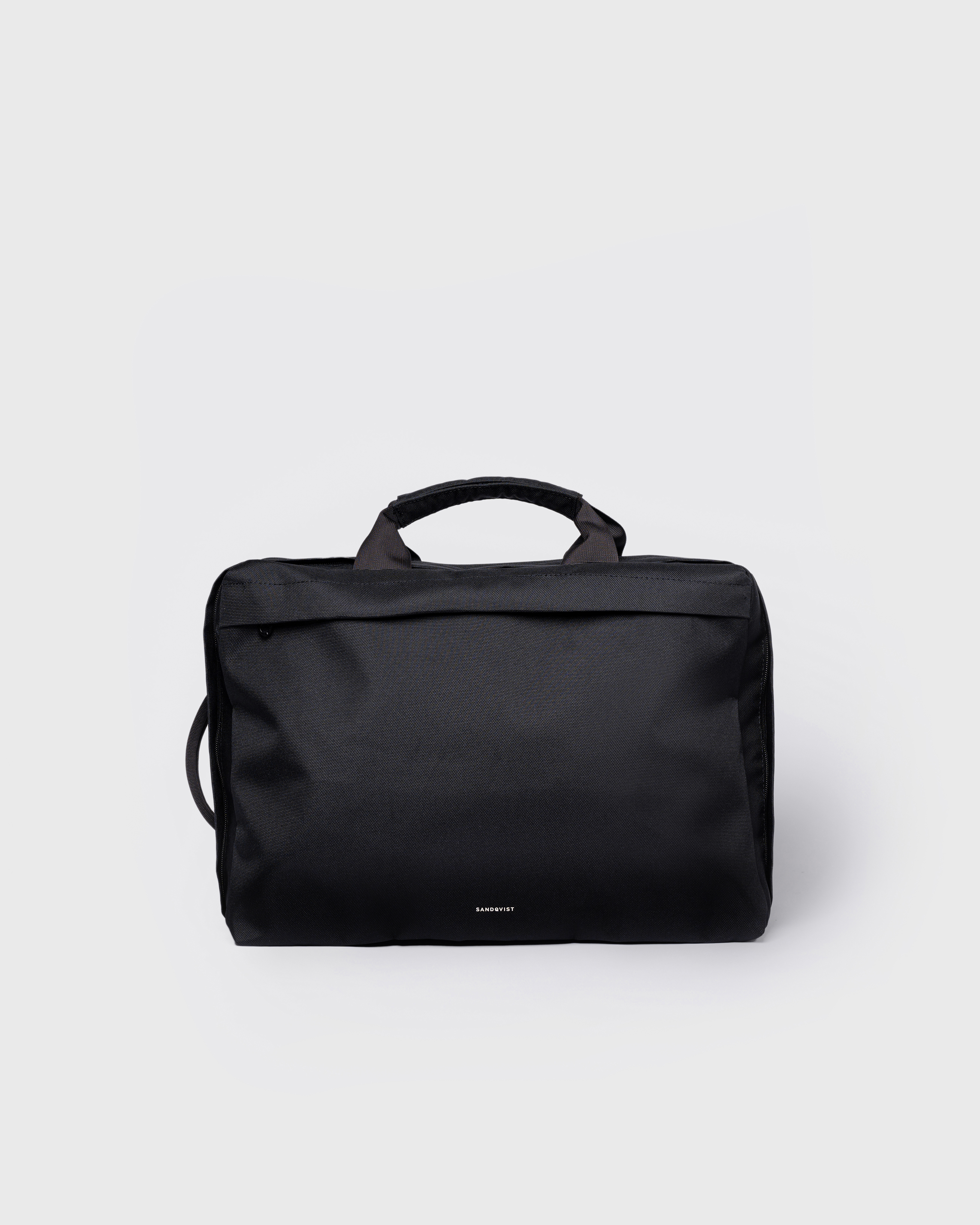 GO 3-Way Bag M, black. Front view, two top-handles and one on the side and one front pocket with a zipper.