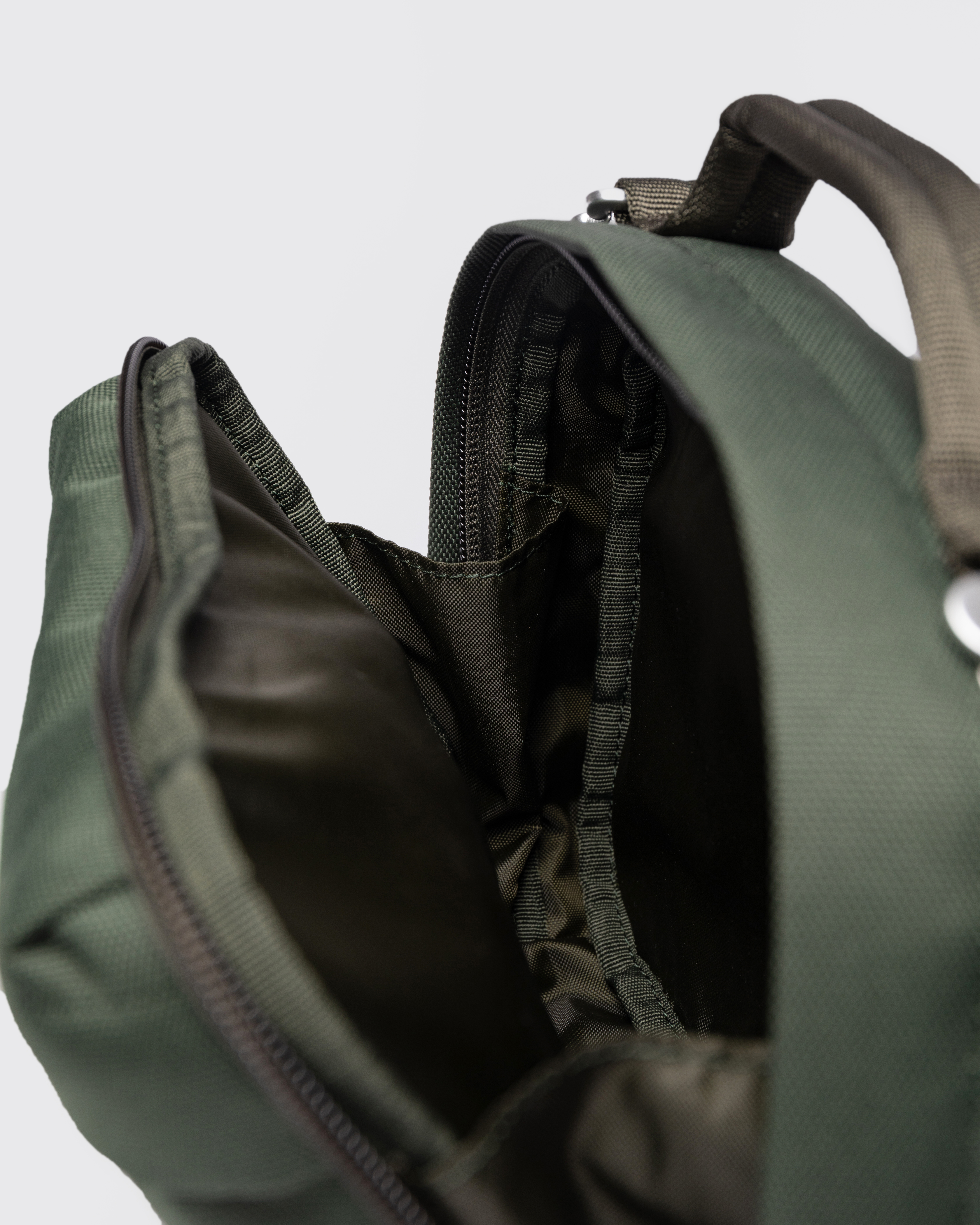 Sandqvist GO Shoulder Bag, green. Inside view, one of the compartments with a zipper, and handle.