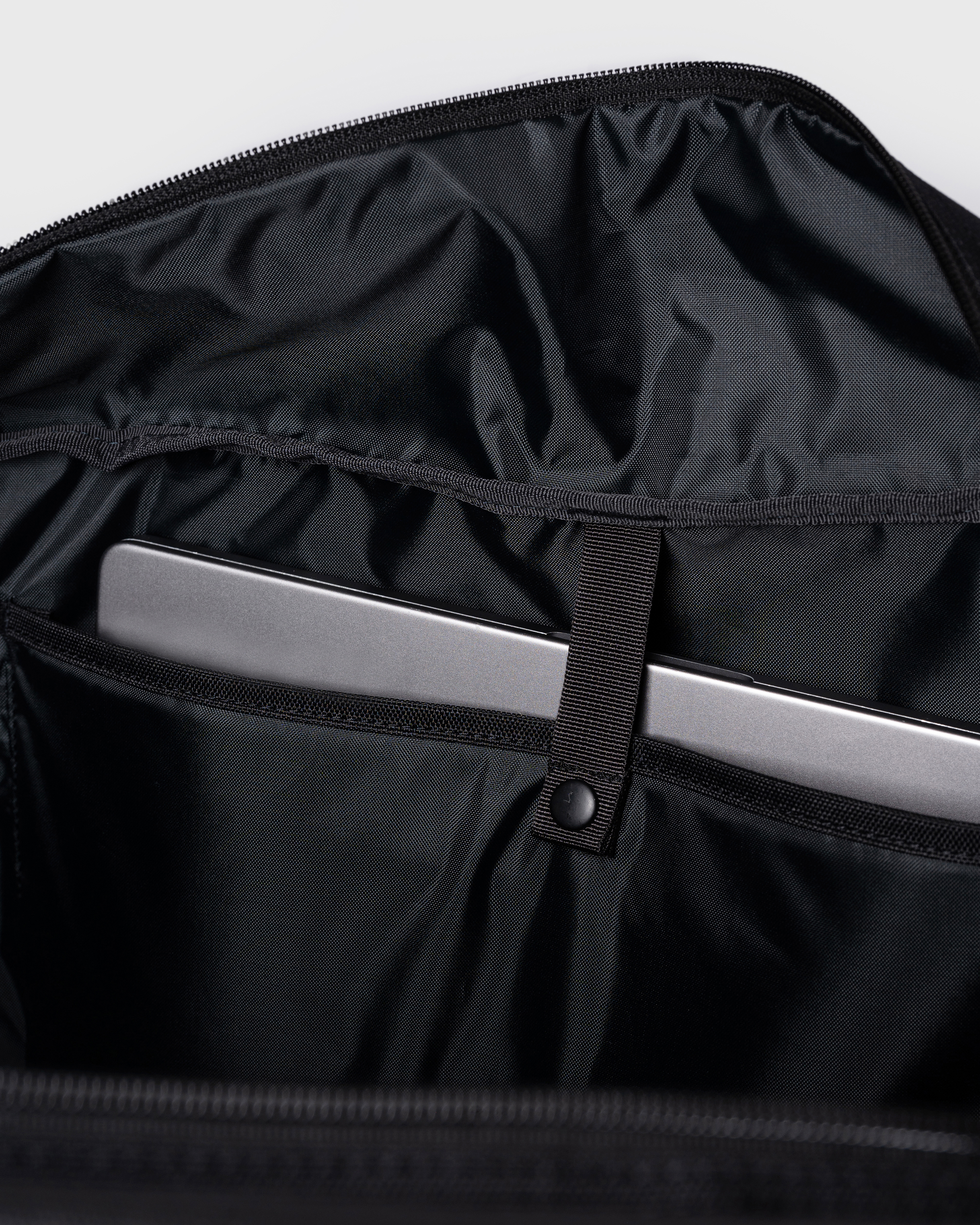Sandqvist GO Weekender L, black. Inside view, laptop compartment with a push button.
