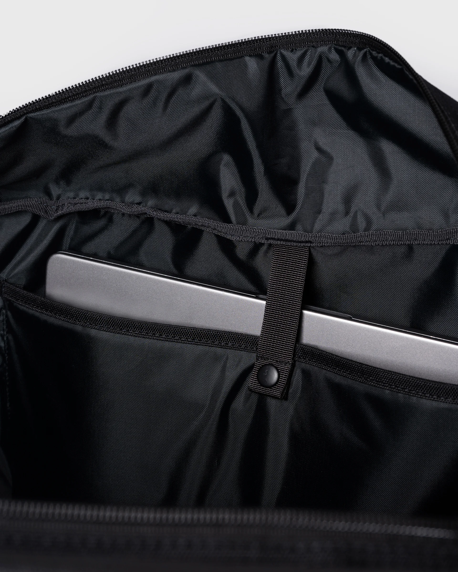 Sandqvist GO Weekender L, black. Inside view, laptop compartment with a push button.