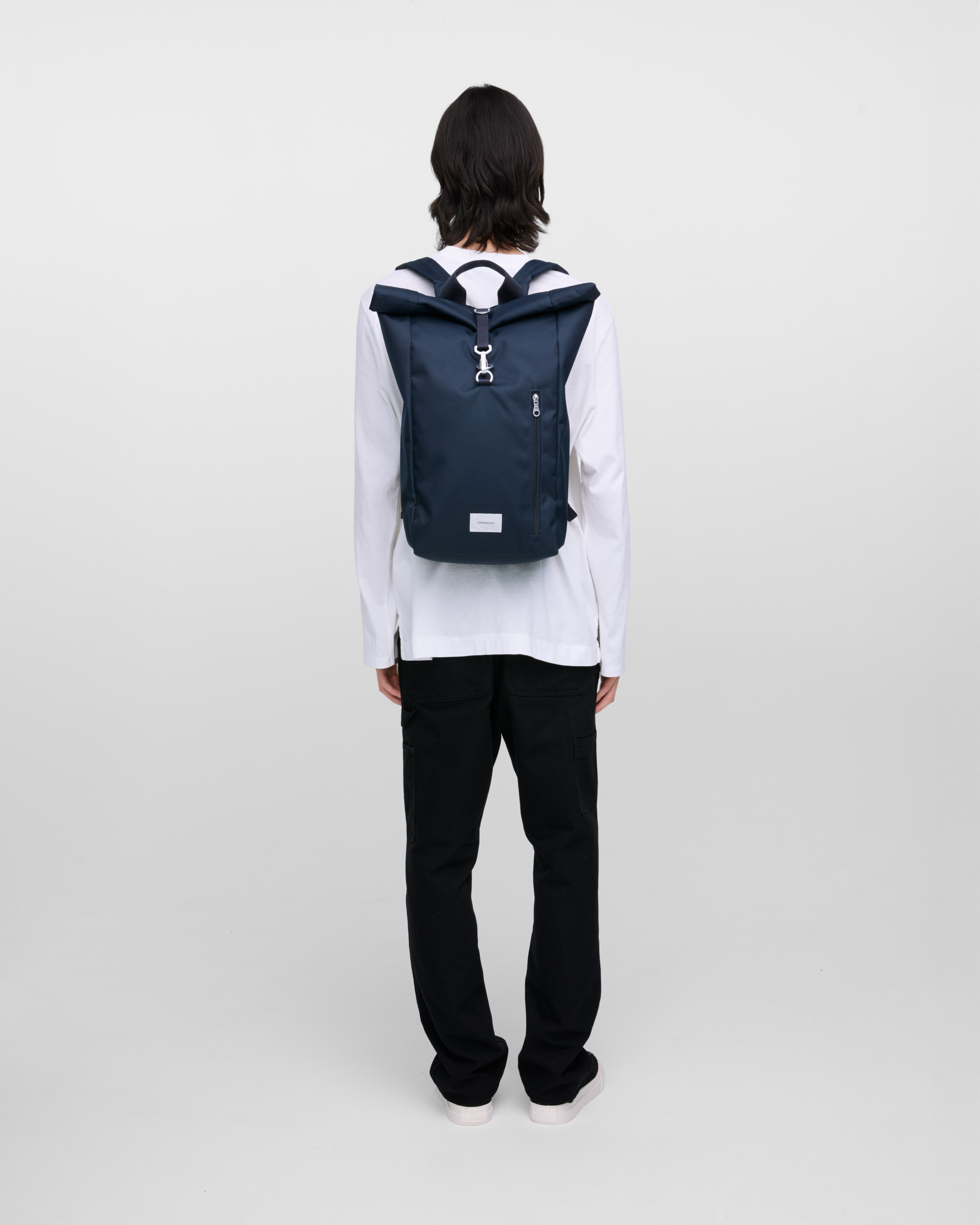 Backpack on back, Sandqvist Ground Rolltop Backpack L in Navy, full-length rear view.