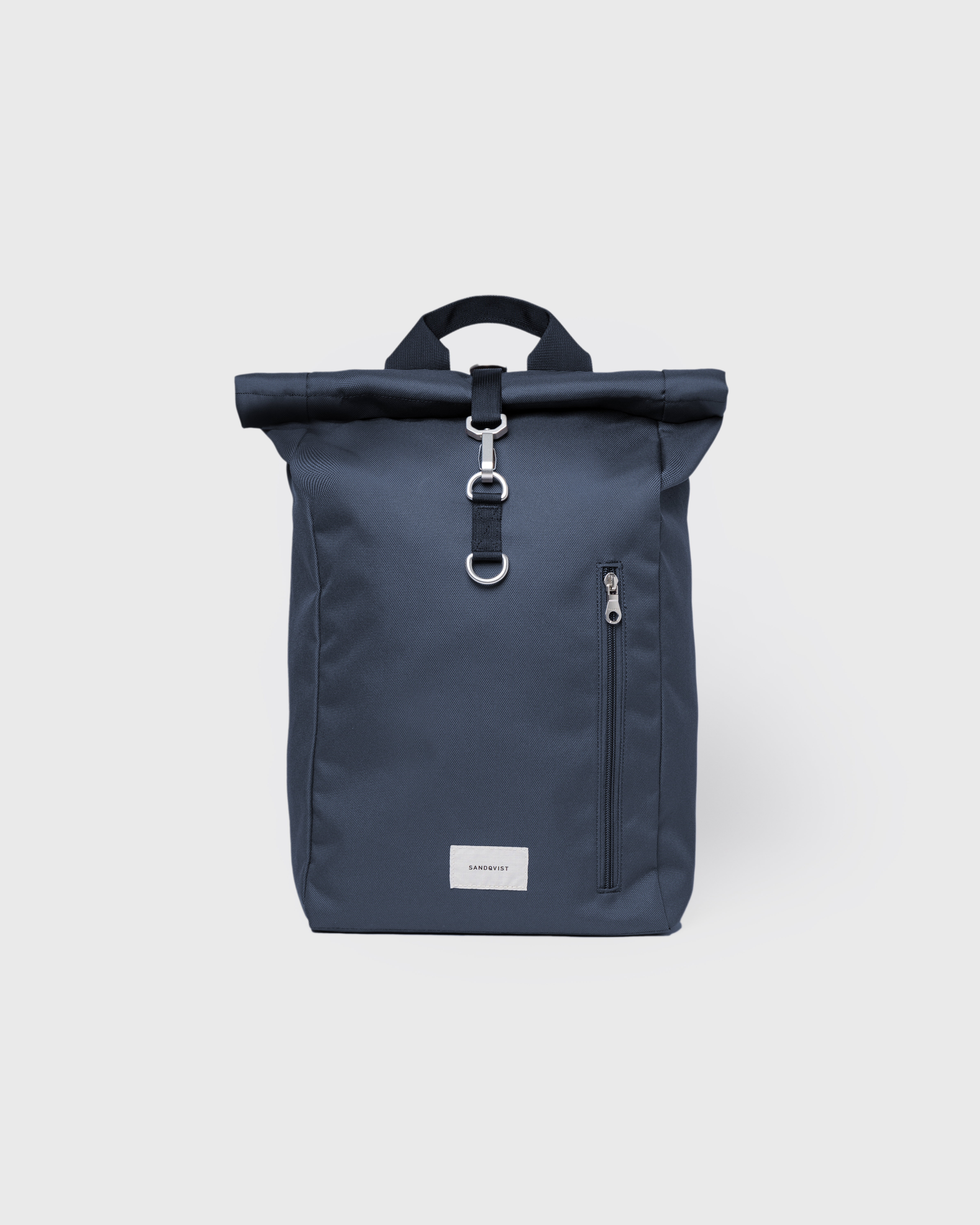 Sandqvist Ground Rolltop Backpack L, blue. Front view, front buckle, handle and pocket with zipper.