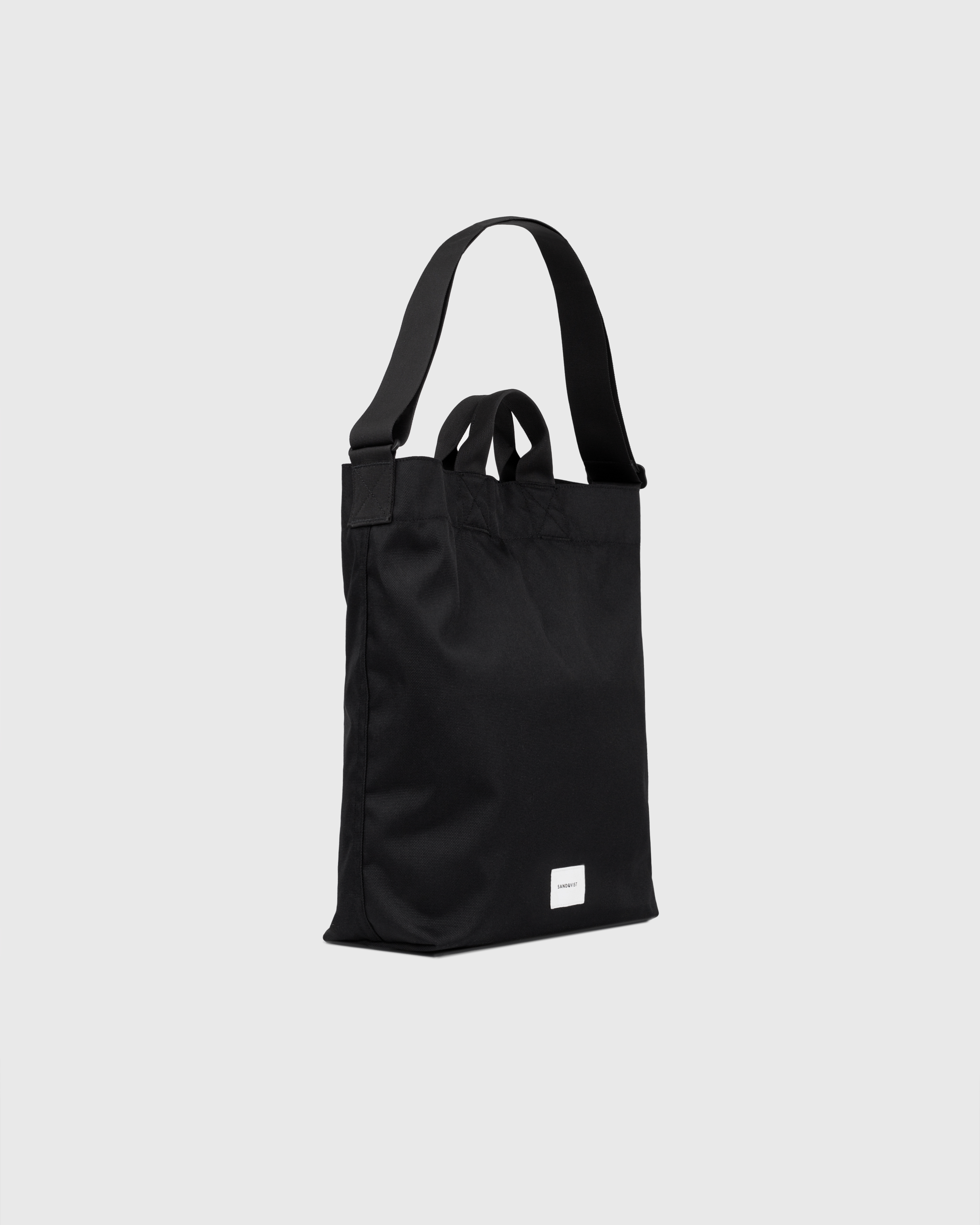 Sandqvist Ground Shopper Bag, black. Side view, handles and shoulder strap.
