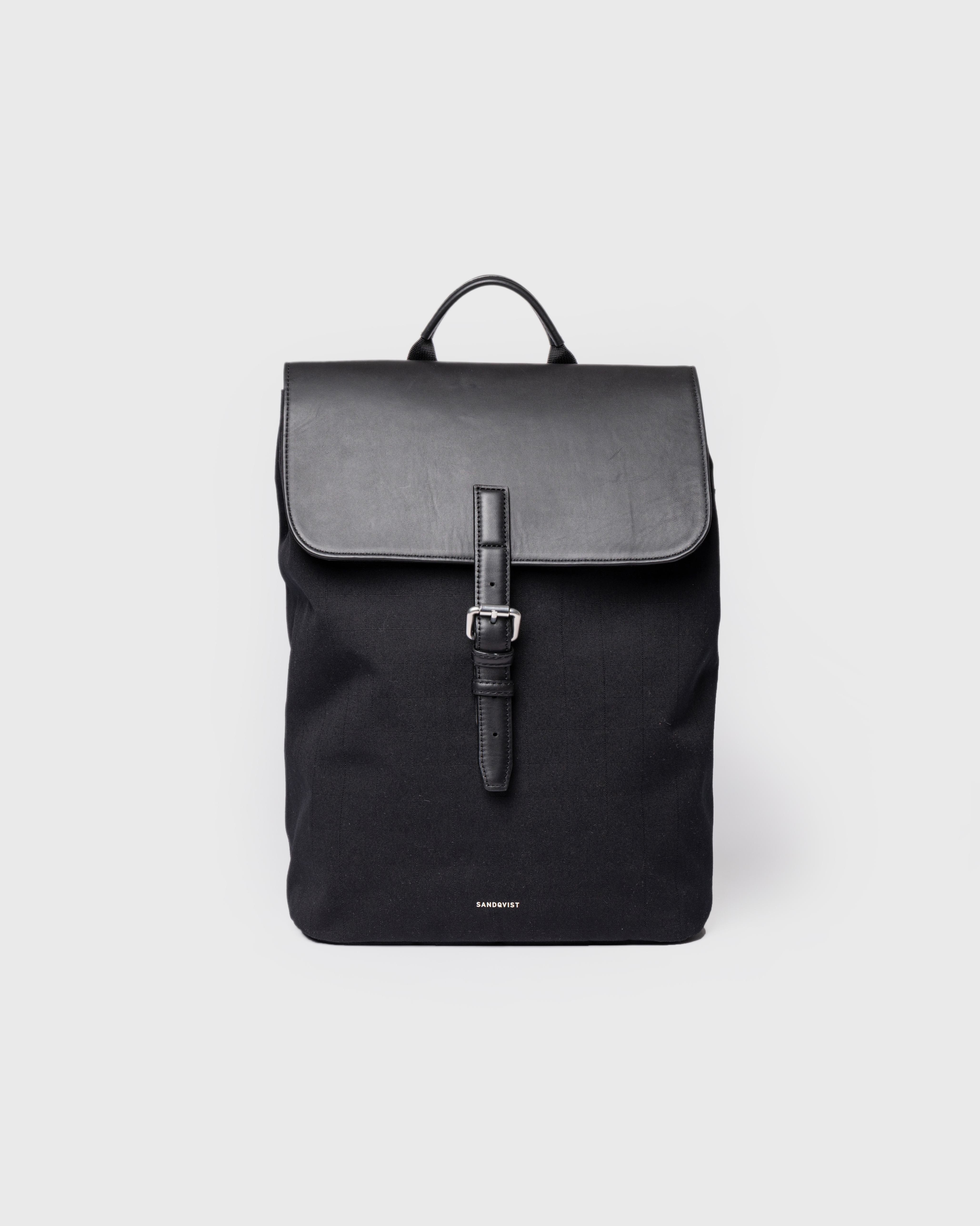 Sandqvist Everyday Lid Backpack M, black. Front view, lid with buckle and handle.