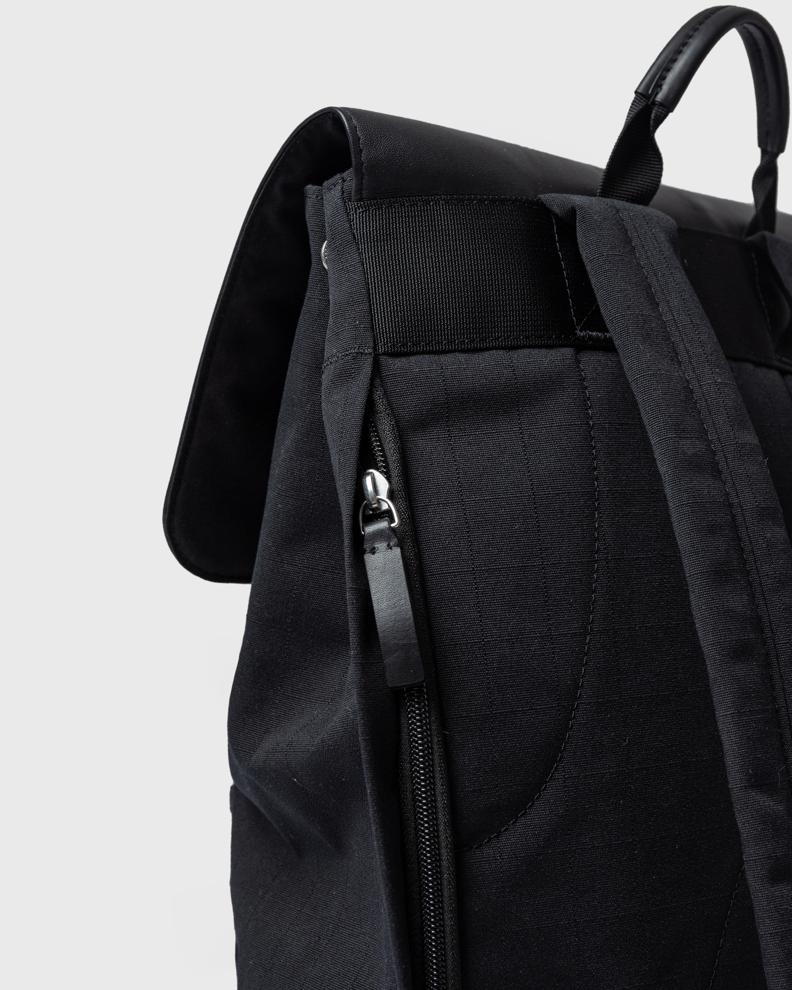 Sandqvist Everyday Lid Backpack M, black. Back view, laptop compartment with zipper, handle and shoulder strap.