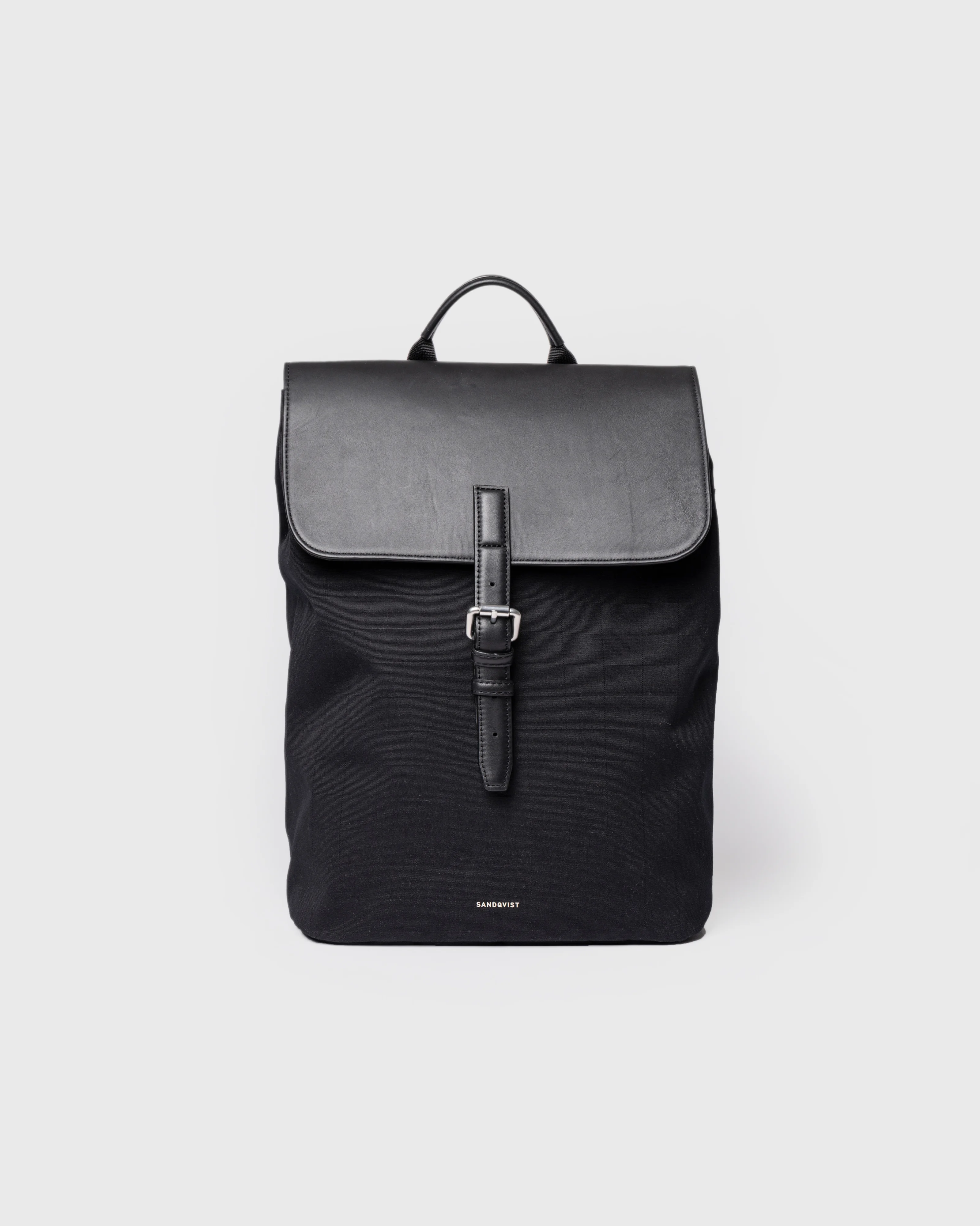 Sandqvist Everyday Lid Backpack M, black. Front view, lid with buckle and handle.