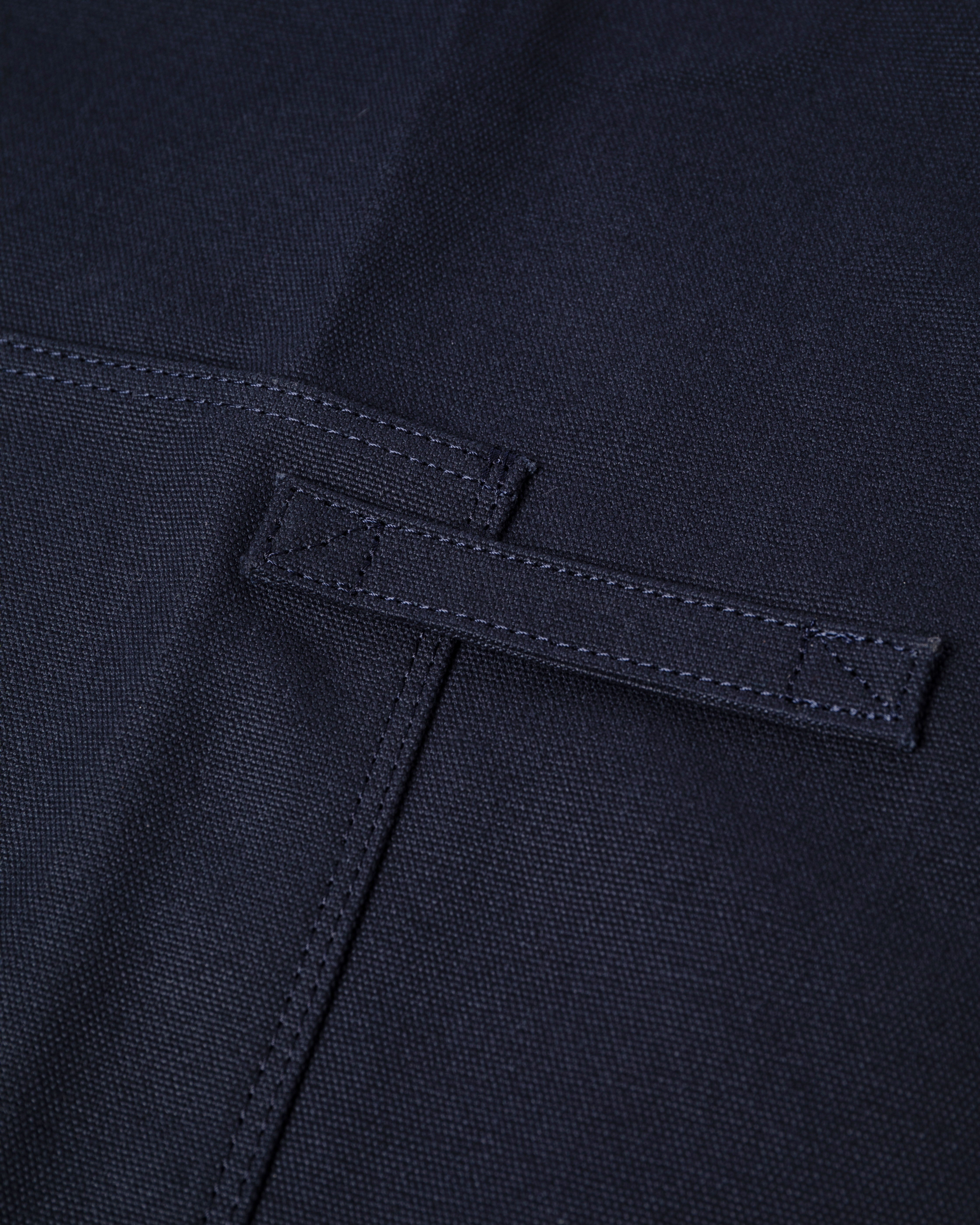 Närbild på förkläde som visar bröstfickan på Sandqvist Apron i marinblått. 