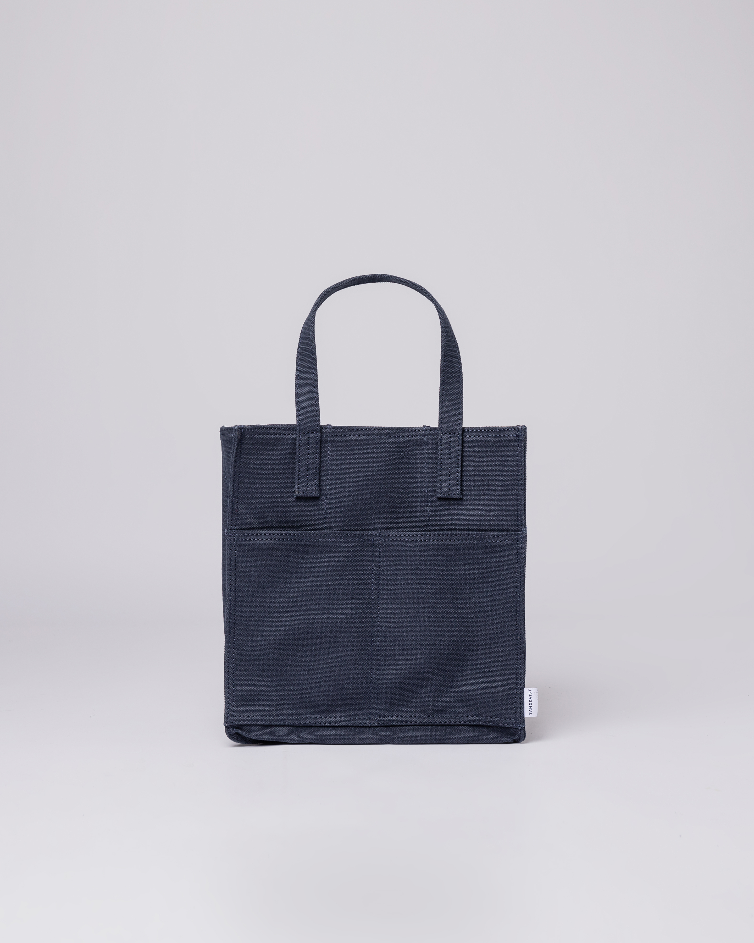 Sac à bouteille. Sandqvist Bottle Bag Navy, vue de face avec poignées supérieures et poche avant.