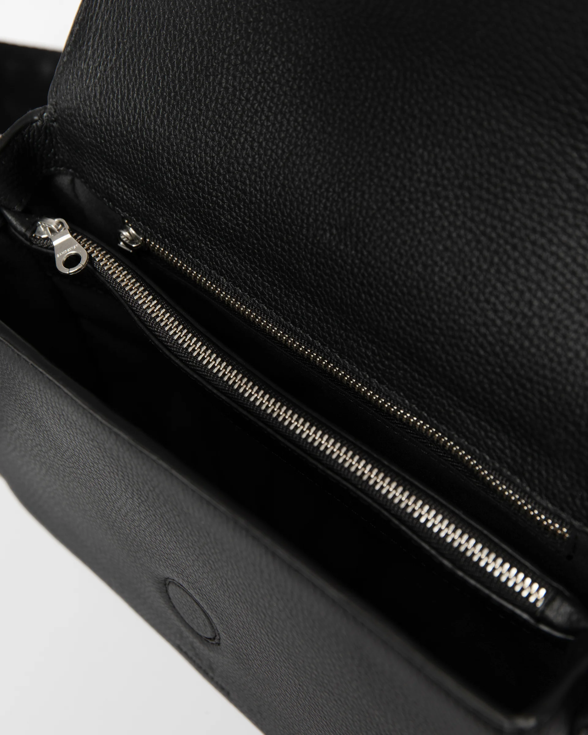 View of the inside of the Sandqvist Agile Crossbody Bag, black, with two zippered pockets.
