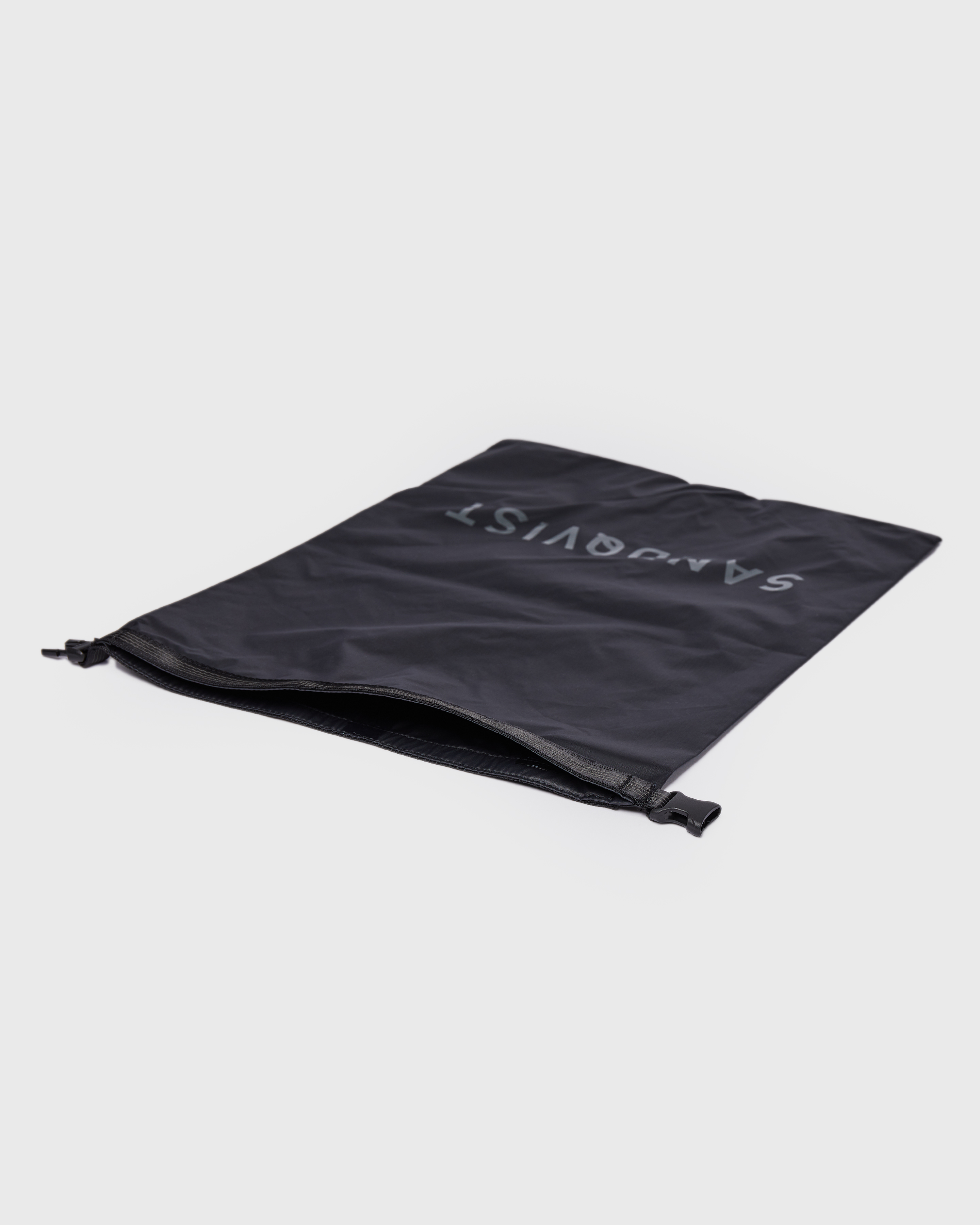 Black dry bag. Front view showing Sandqvist ITEMS Dry bag laying on flat surface.