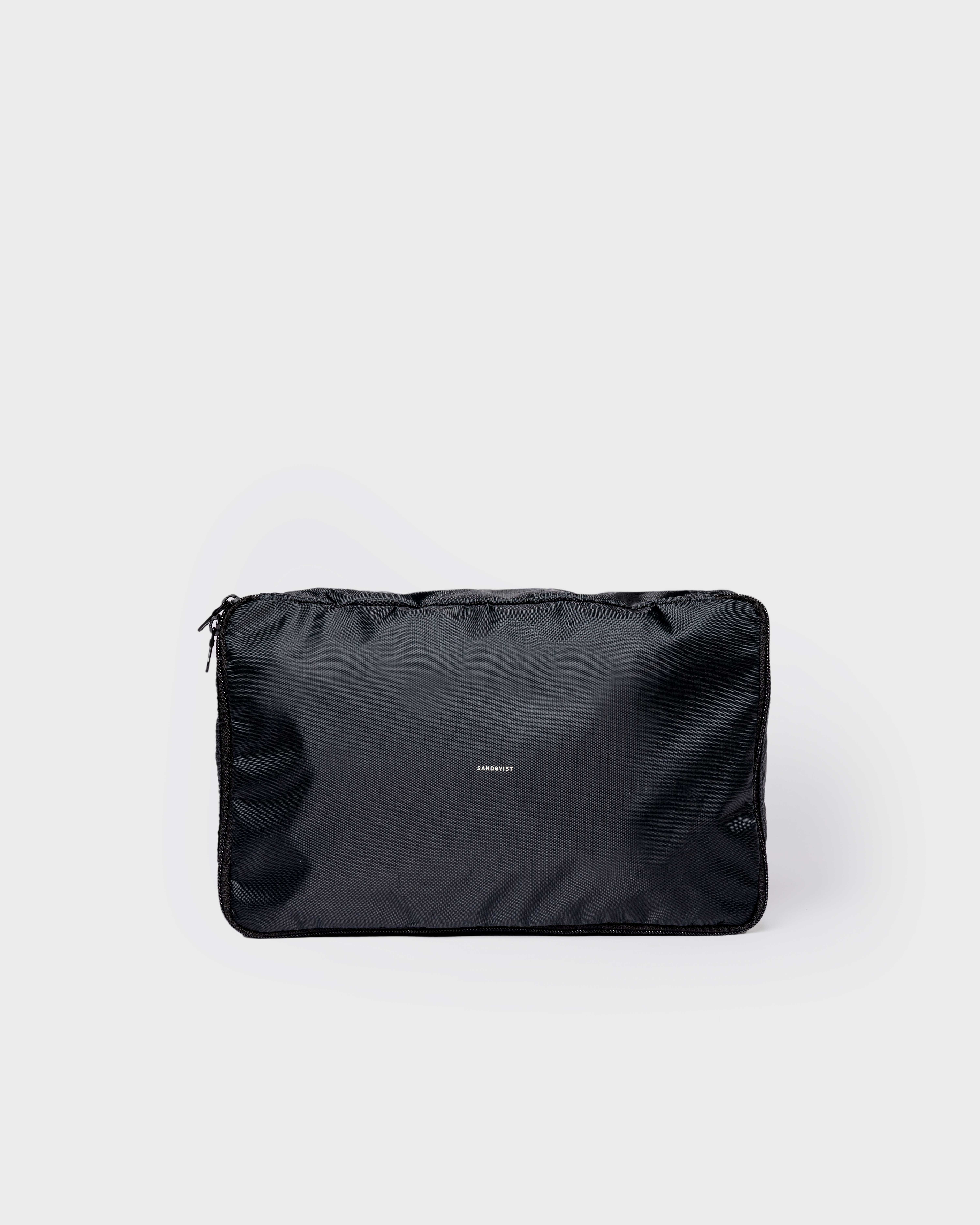 Black packing Cube with Sandqvist Logotype. Front view showing Sandqvist ITEMS Packing Cube M in black with zipper closure.