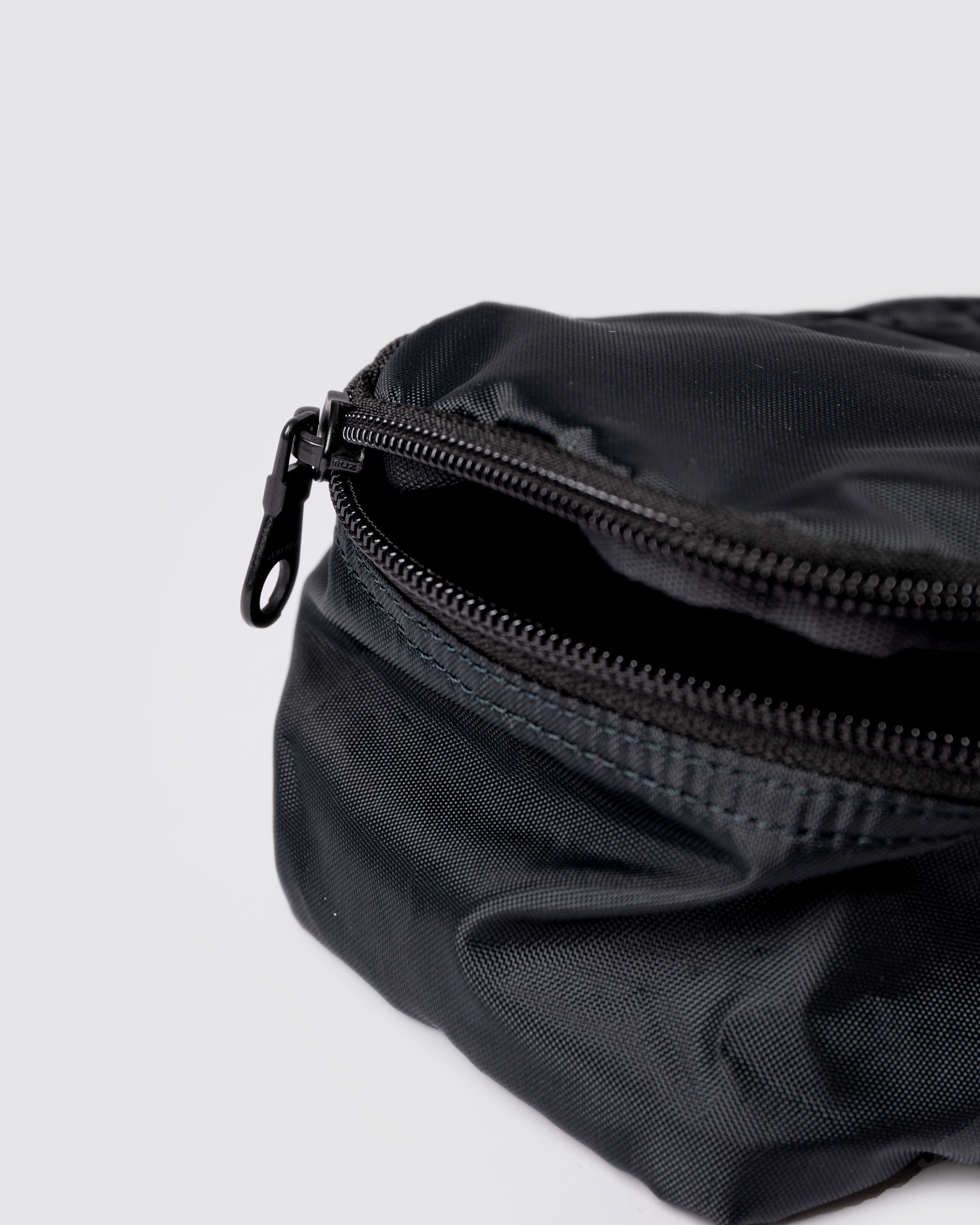 Black packing Cube. Close up view of Sandqvist ITEMS Packing Cube S showing opened zipper. 