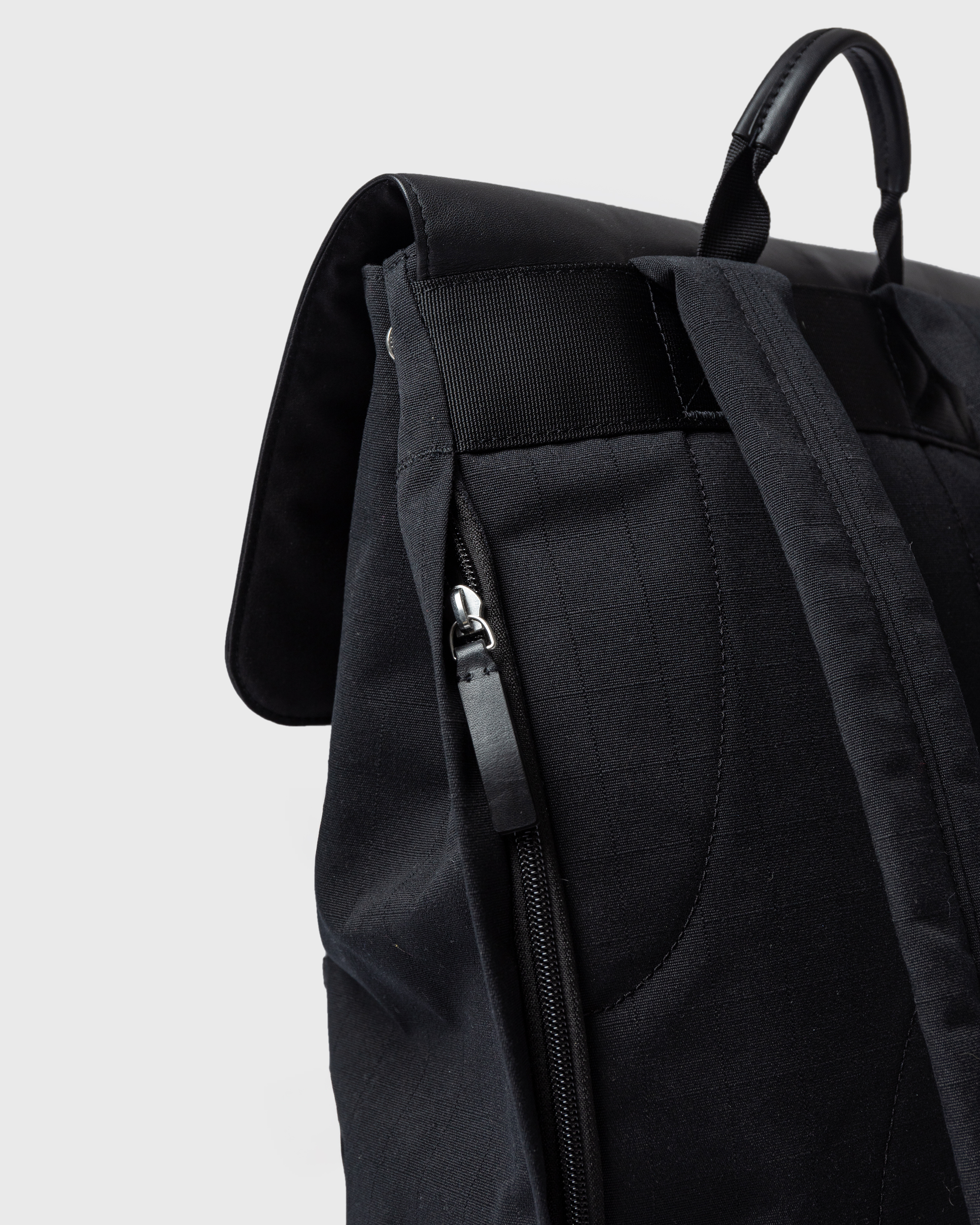 Sandqvist Everyday Lid Backpack L, black. Back view, outer laptop compartment with zipper, handle and shoulder strap.