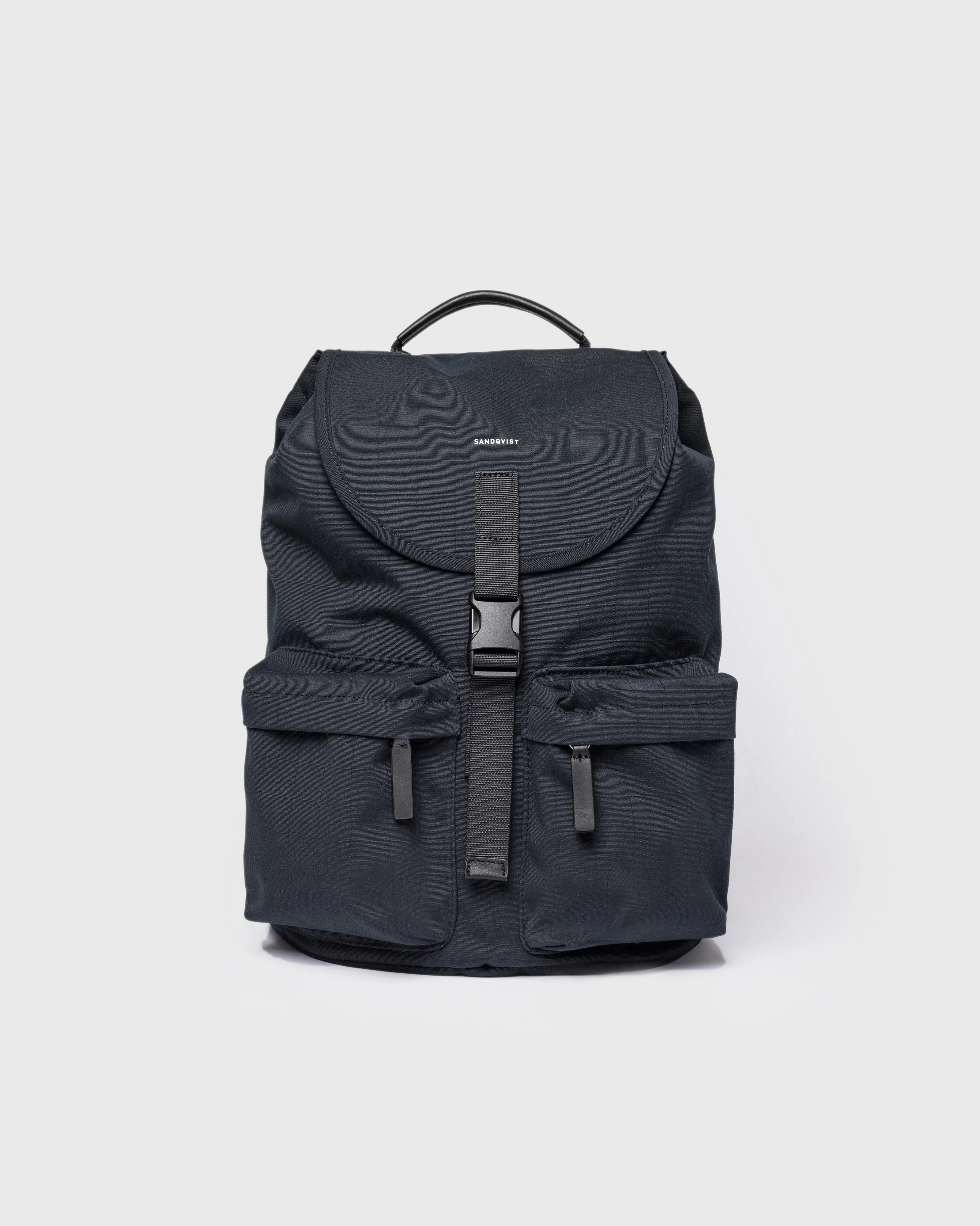 Sandqvist Everyday Rucksack, black. Front view, lid with buckle, two pockets with zippers and handle.