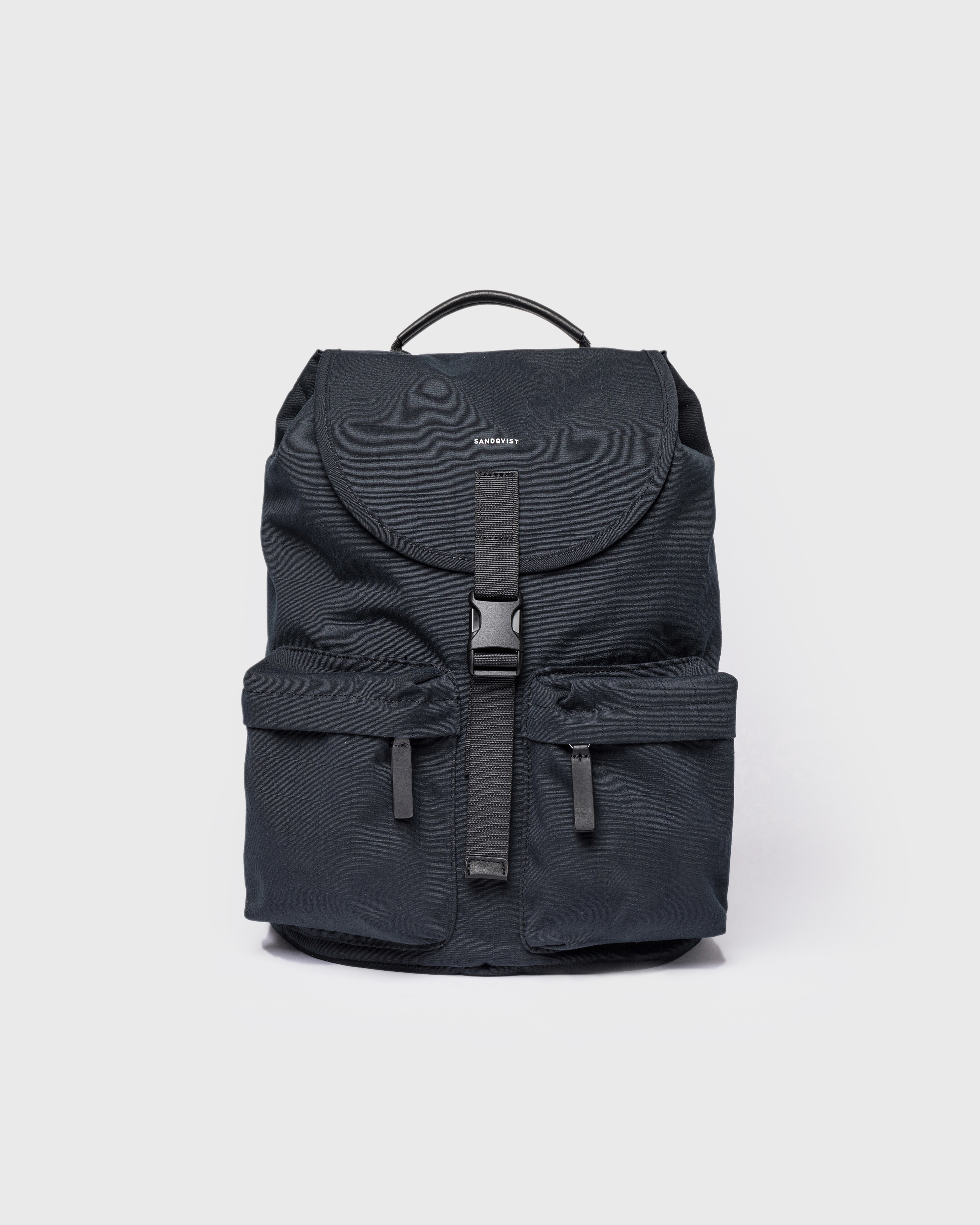 Sandqvist Everyday Rucksack, black. Front view, lid with buckle, two pockets with zippers and handle.