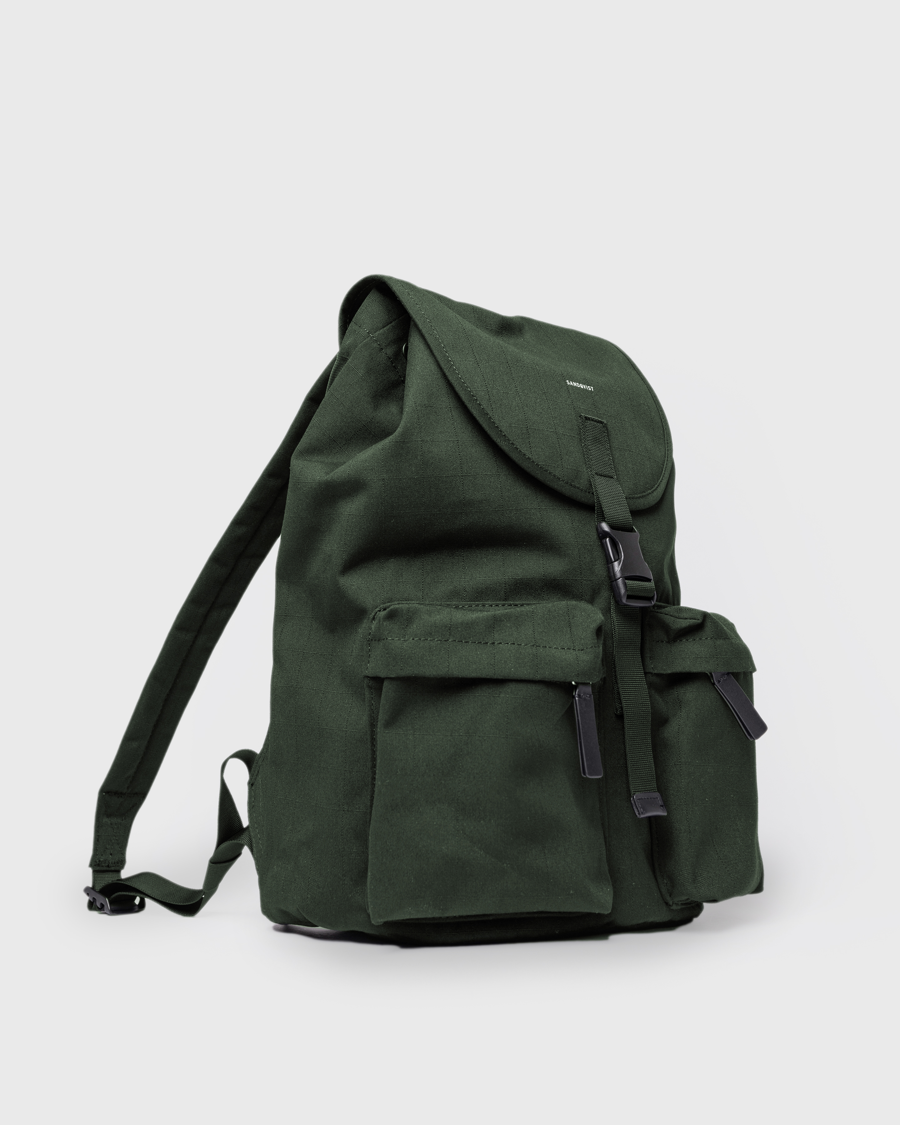 Sandqvist Everyday Rucksack, green. Side view, lid with buckle, two pockets with zippers and shoulder strap.