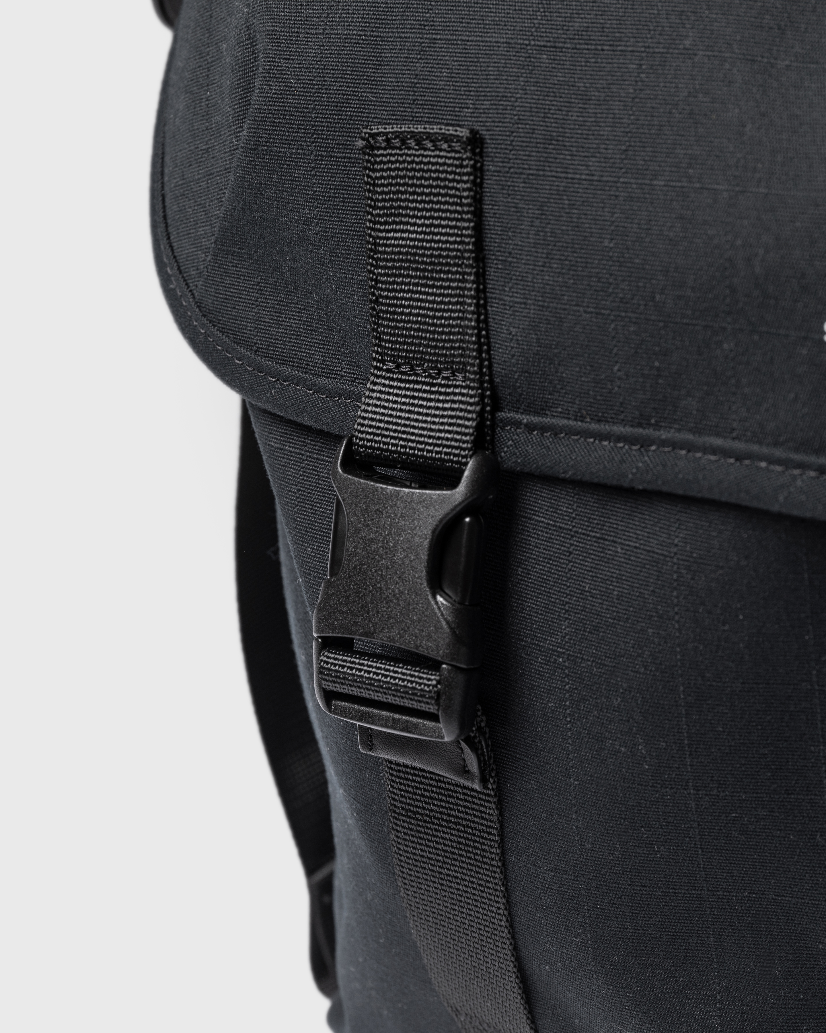 Sandqvist Everyday messenger bag, black. Close-up of one buckle for the main compartment.