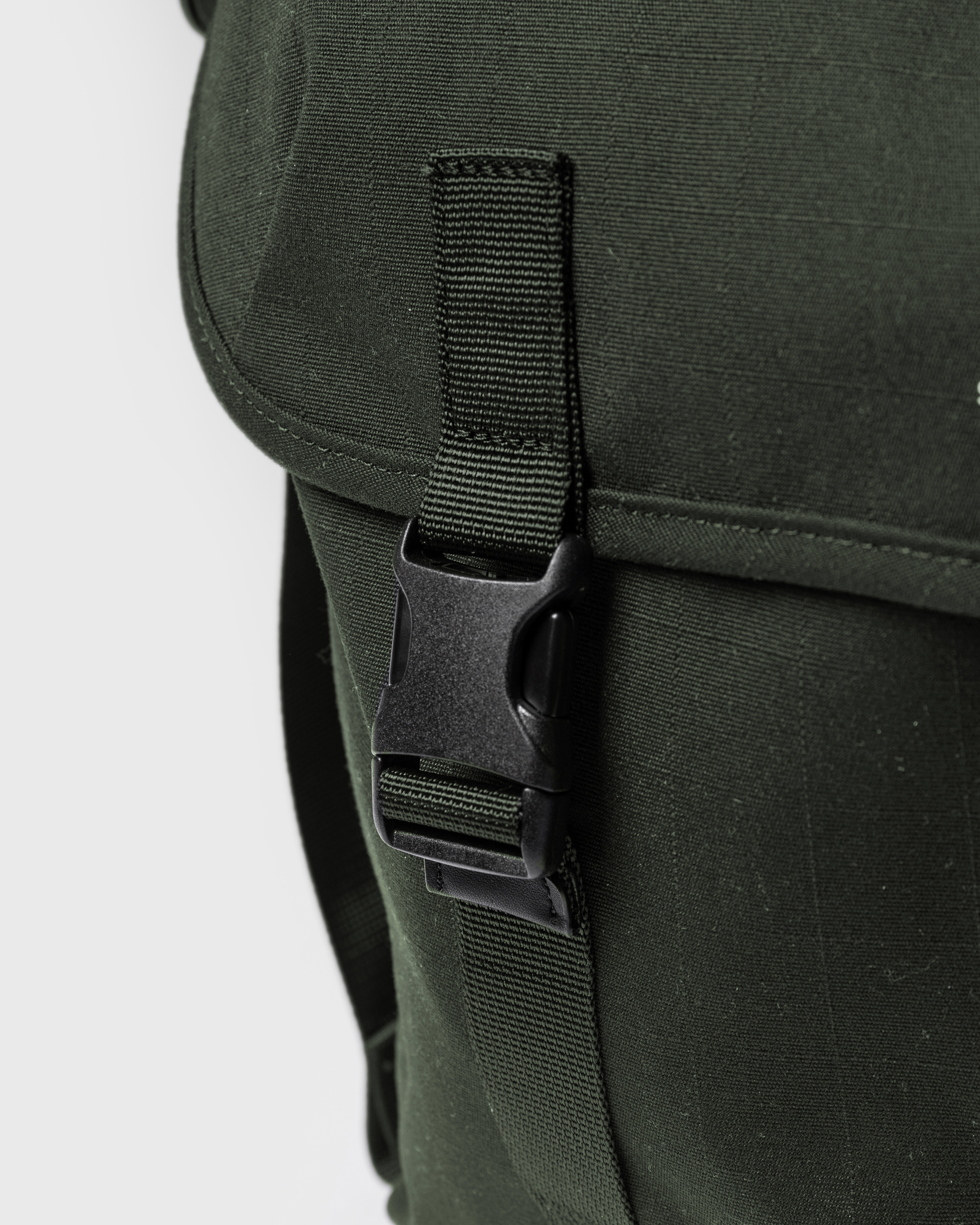 Sandqvist Everyday messenger bag, green. Close-up of one buckle for the main compartment.