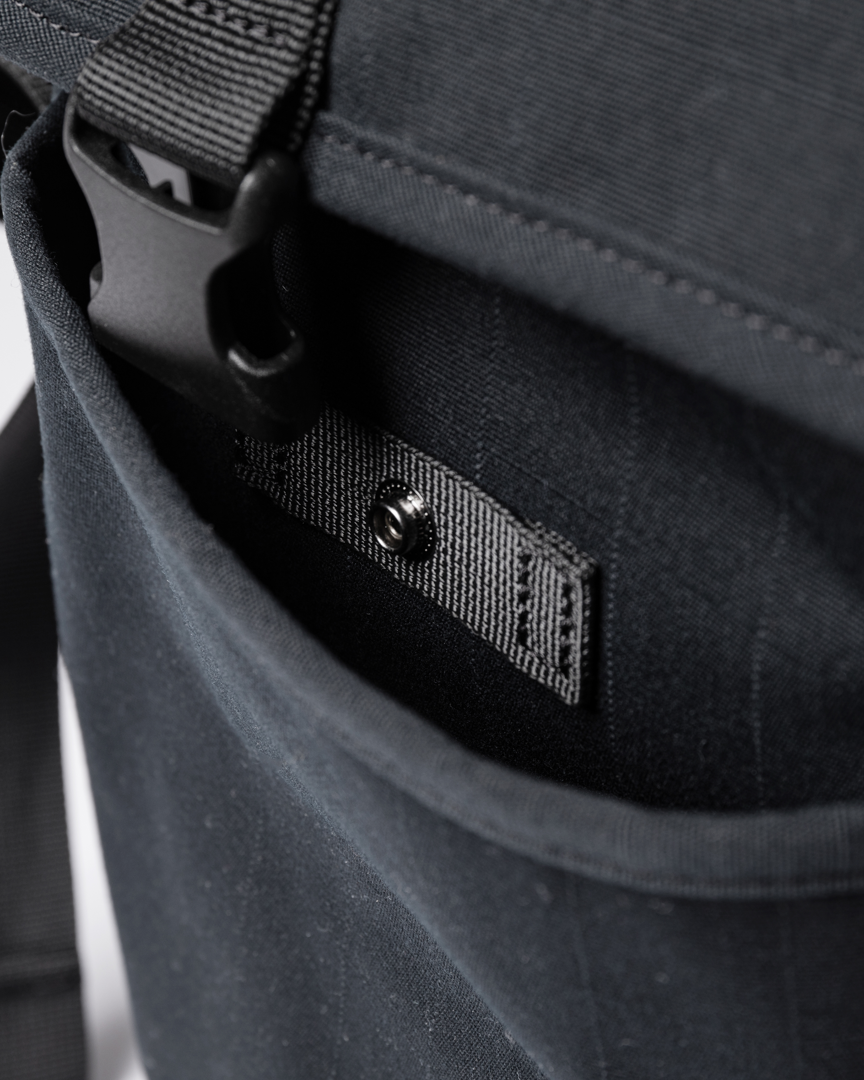 Sandqvist Everyday messenger bag, black. Inside view, front pocket with snap button and buckle.